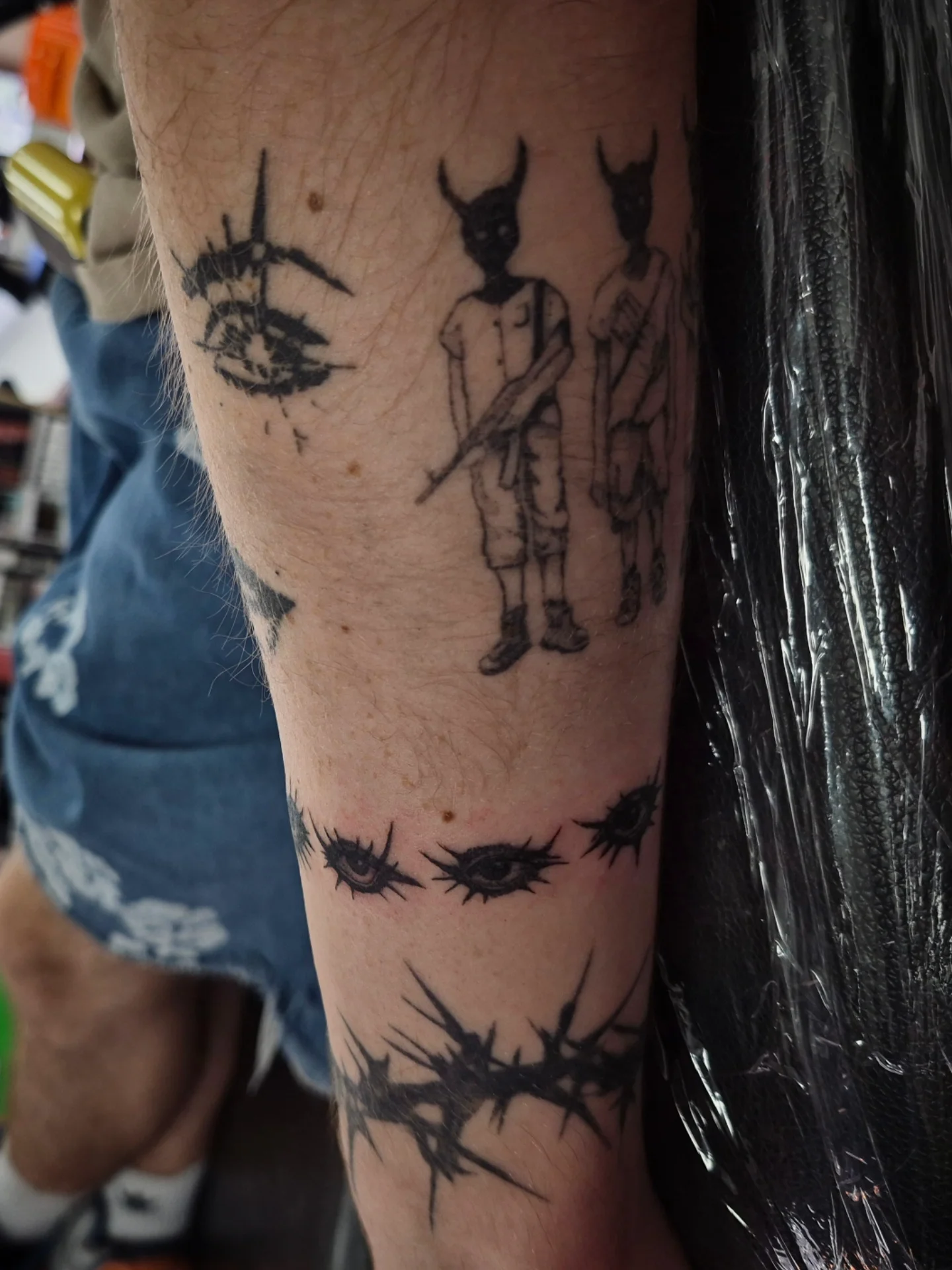 Eyes and demons black and grey tattoo on the forearm by Lydia Kiley