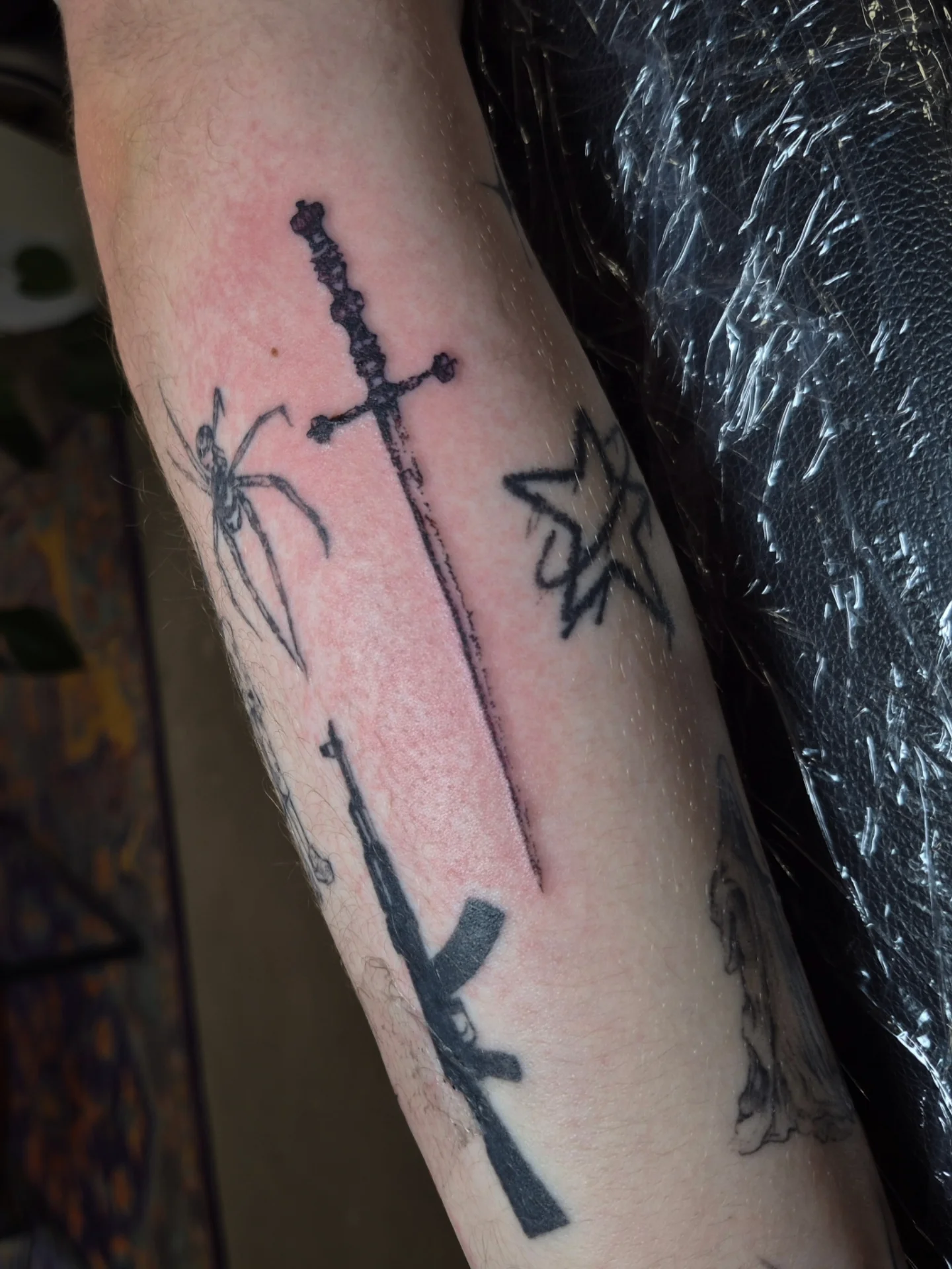 Sword and star black and grey tattoo on the forearm by Lydia Kiley