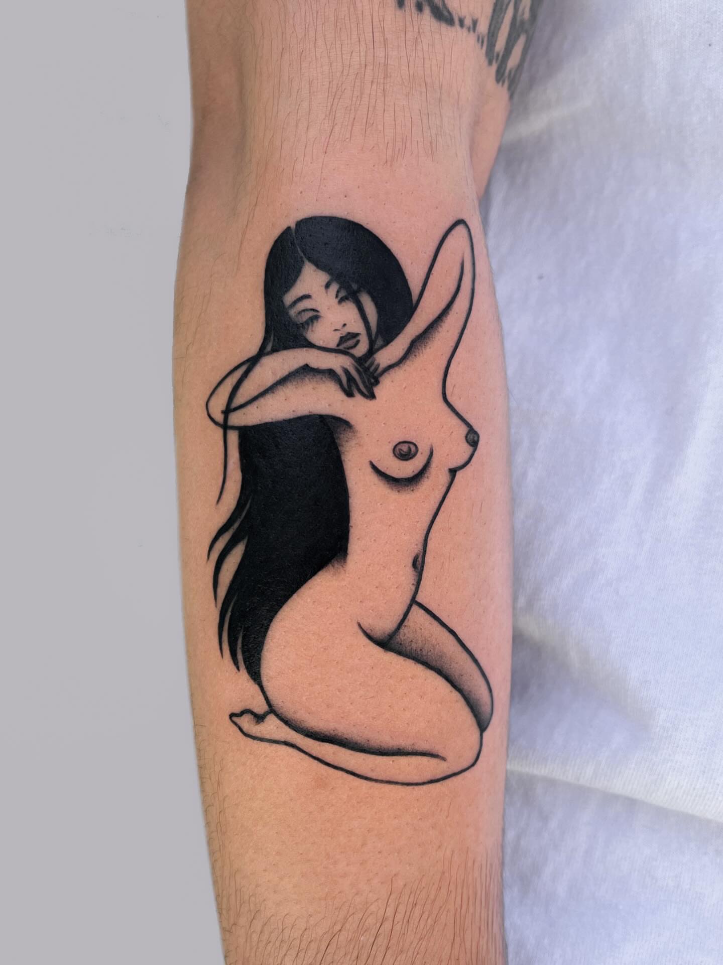 Nude woman black and grey tattoo on the forearm by nina