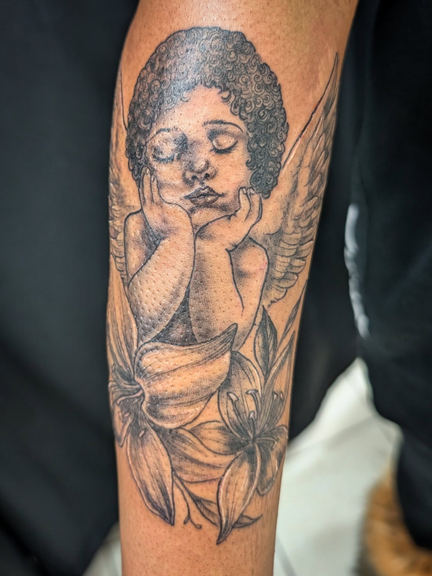 Angel with lilies realism tattoo on the forearm by Katherine