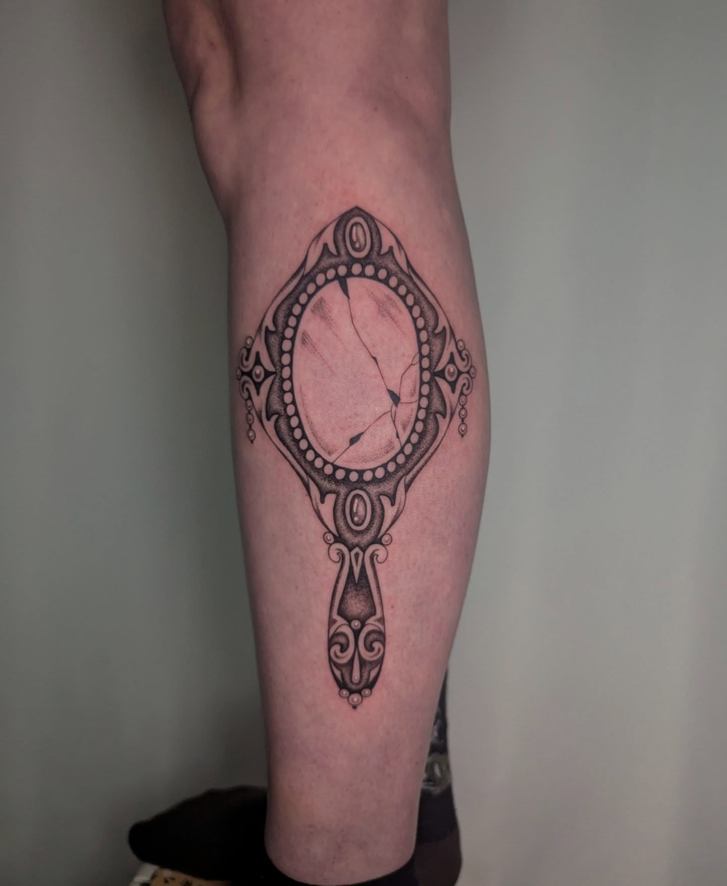 Mirror dotwork tattoo on the forearm by Courtney Yaddof