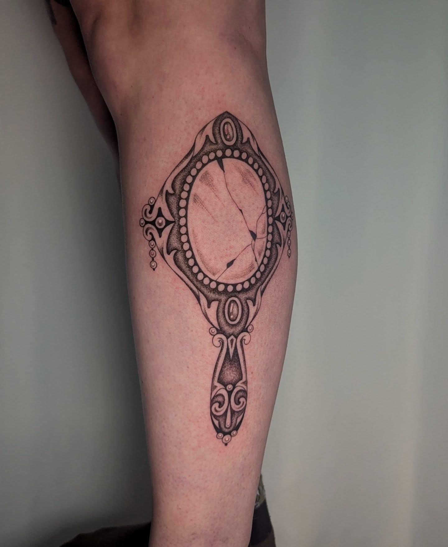 Mirror dotwork tattoo on the forearm by Courtney Yaddof