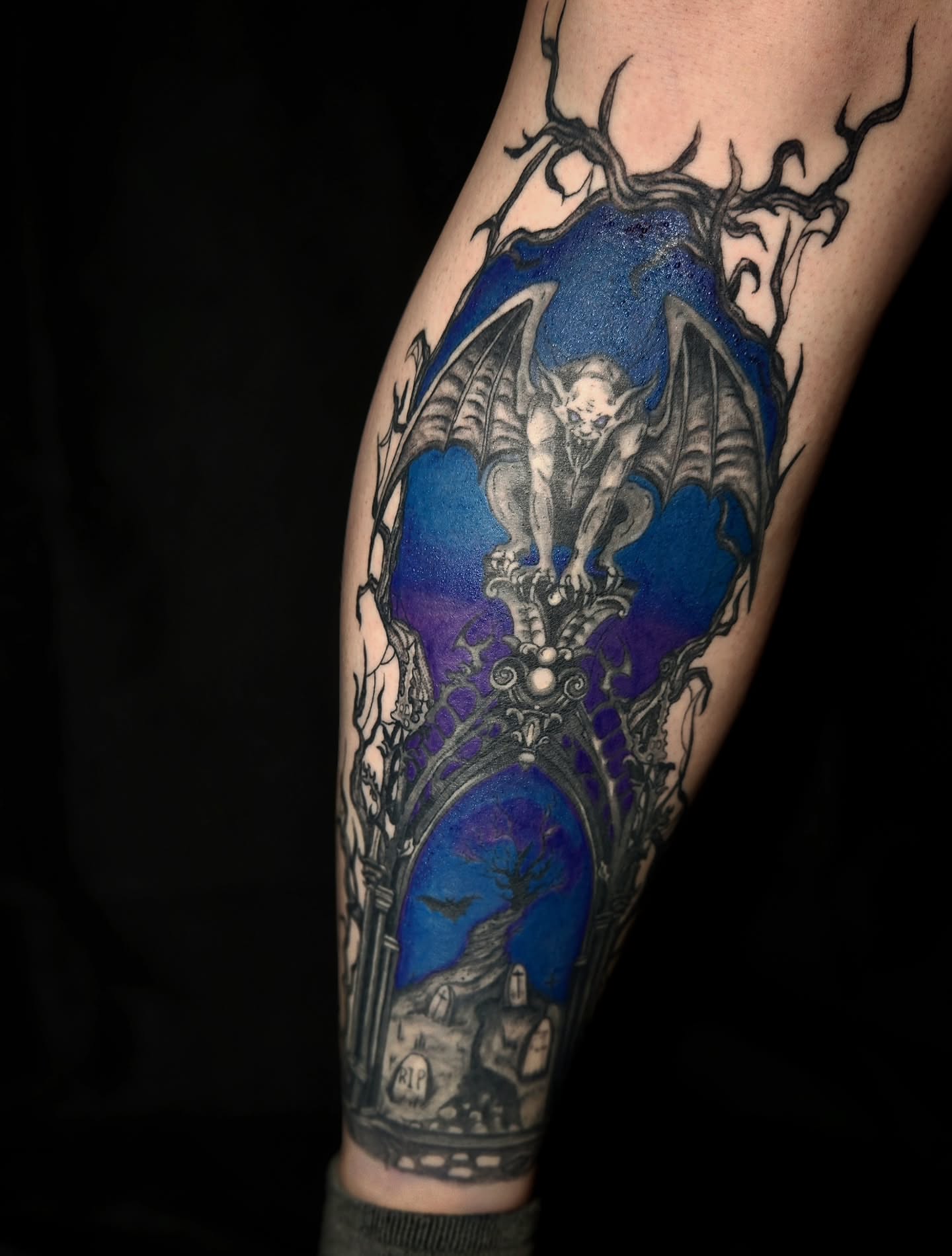 Gargoyle and cemetery dark realism tattoo on the forearm by Ashly Renee