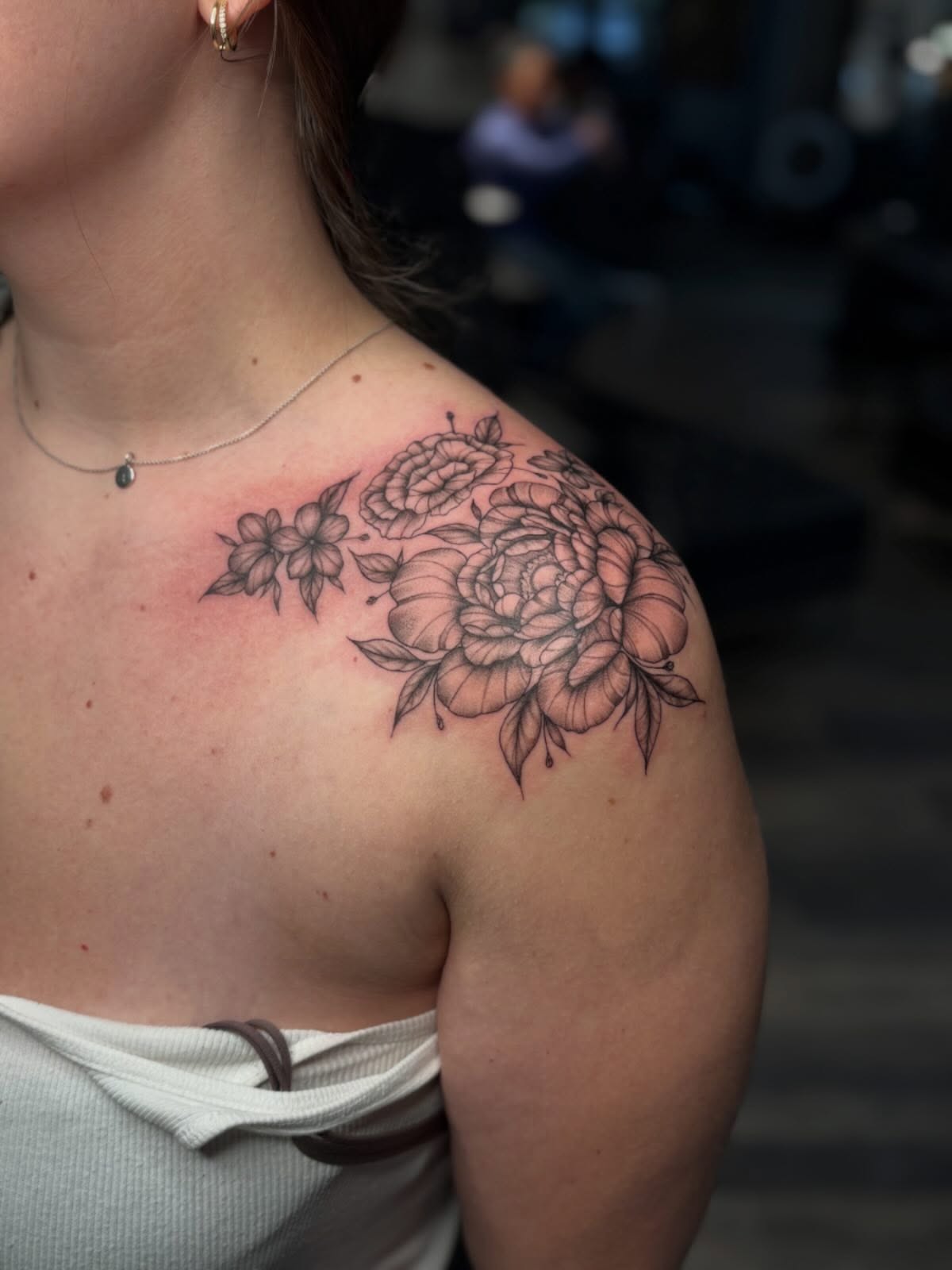Floral arrangement black and grey tattoo on the shoulder by Tessa Simmons - Tattoo Artist