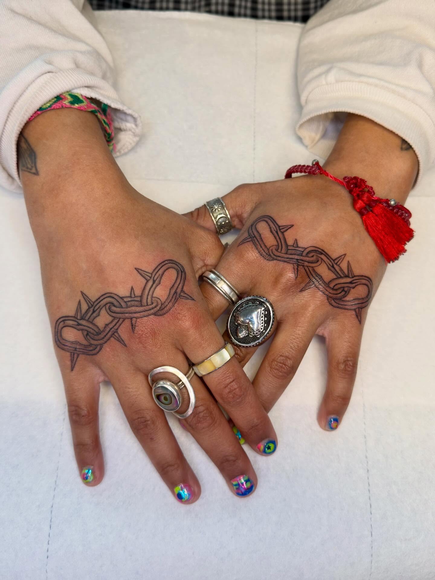 Chain with barbed wire black and grey tattoo on the hand by Nayoung, San Francisco, California