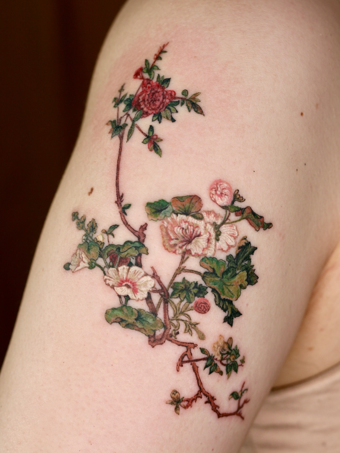 Floral arrangement realism tattoo on the upper arm by Isle