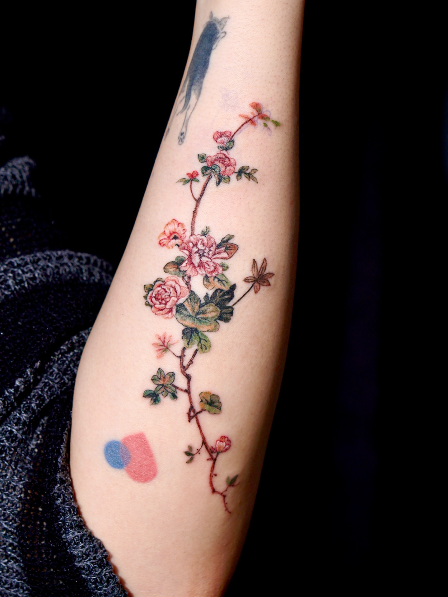 Floral vine watercolor tattoo on the forearm by Isle