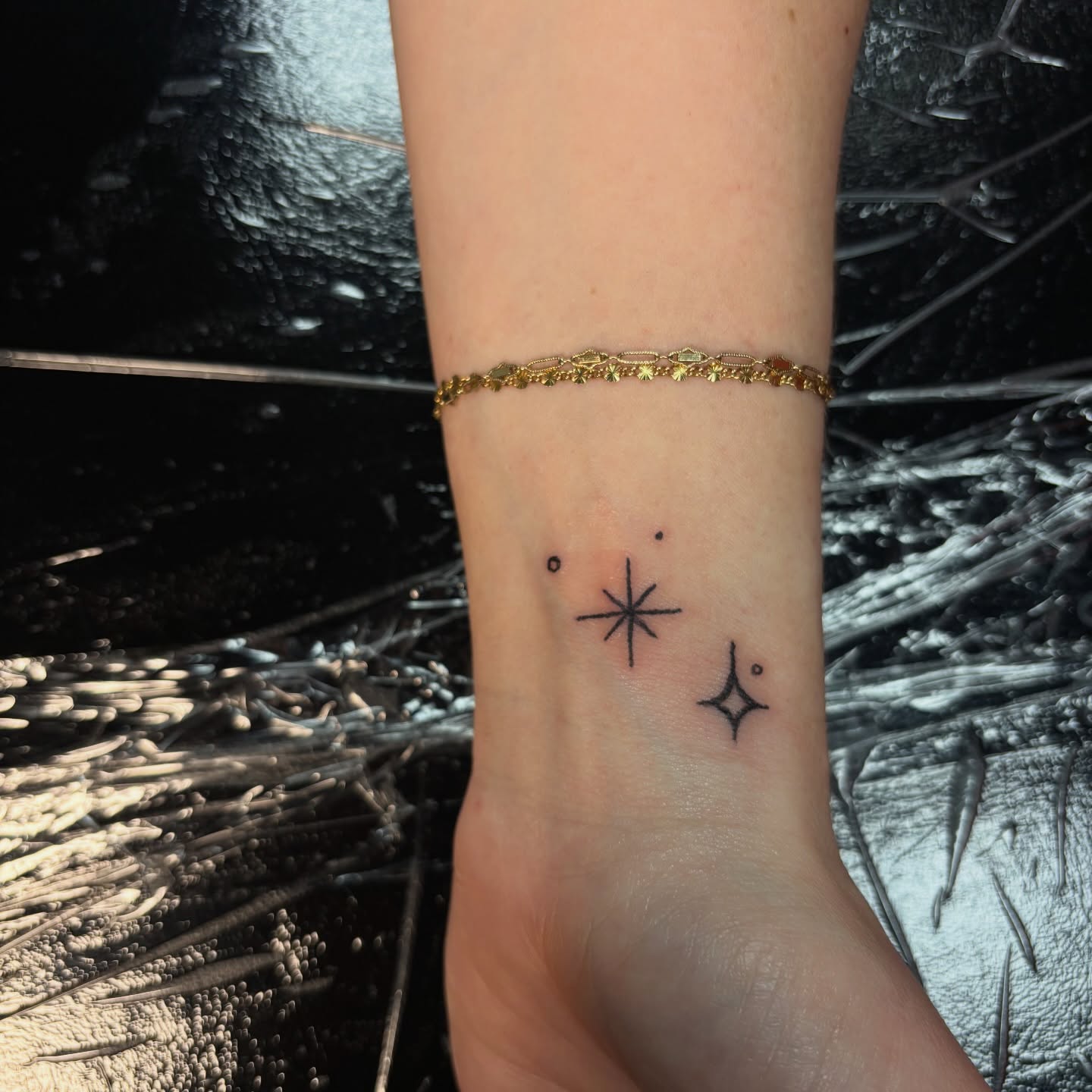 Starburst and stars minimalist tattoo on the forearm by Rachel