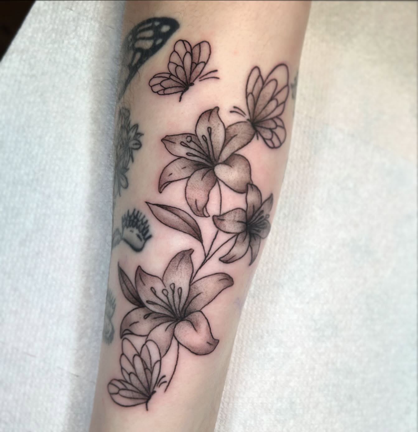 Lilies and butterflies black and grey tattoo on the forearm by 🕸🖤Kass🖤🕸