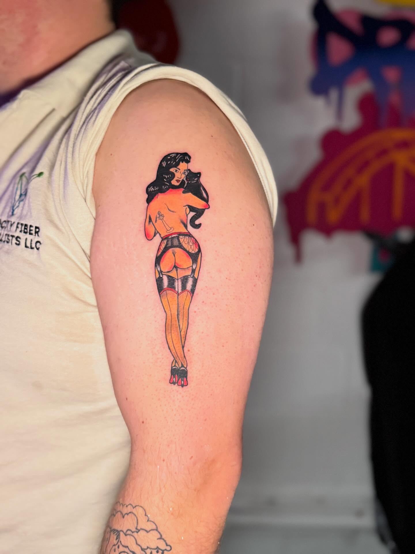Pin-up girl American traditional tattoo on the upper arm by dotMX
