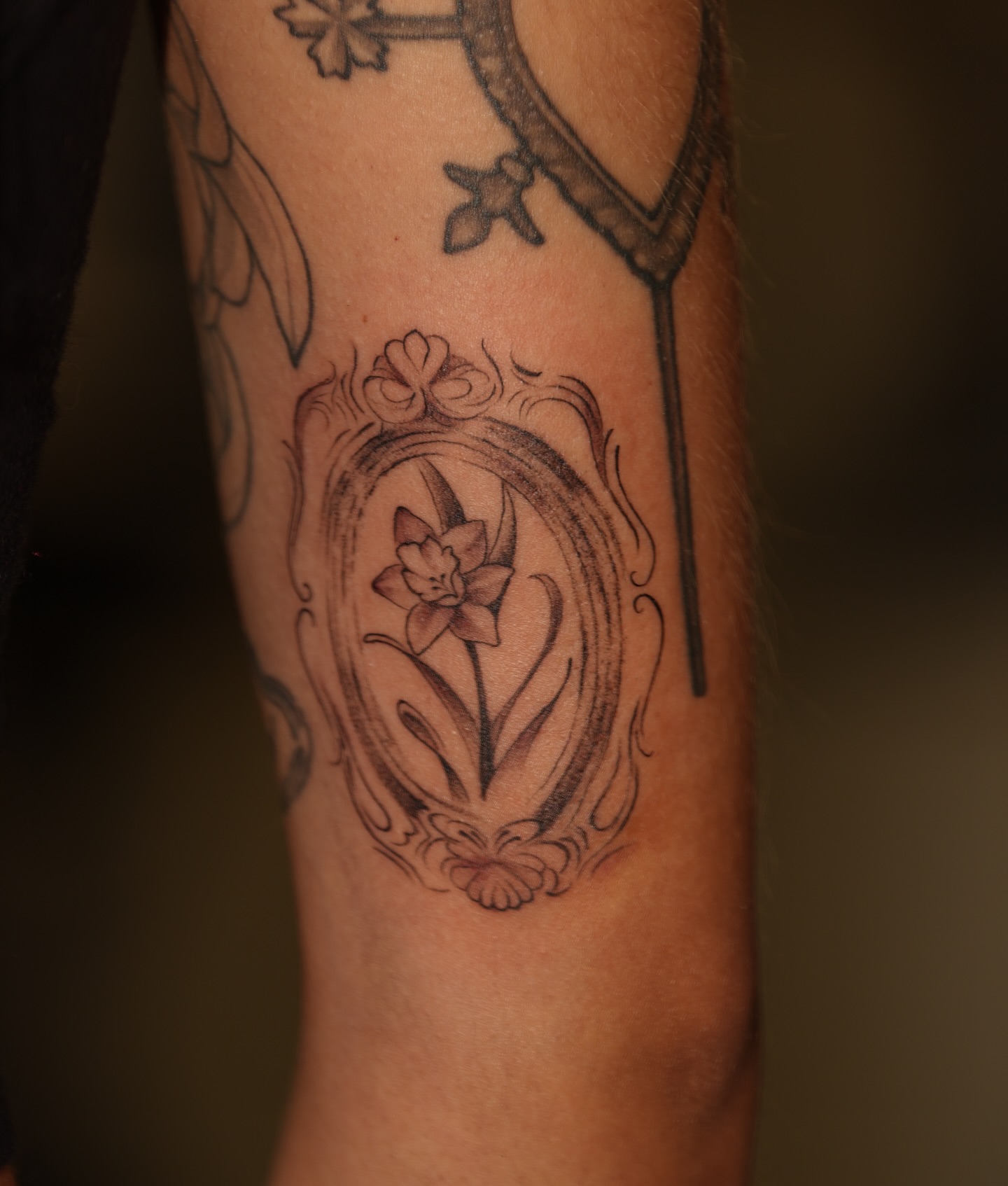 Flower in ornate frame black and grey tattoo on the forearm by Kevin Betancourt