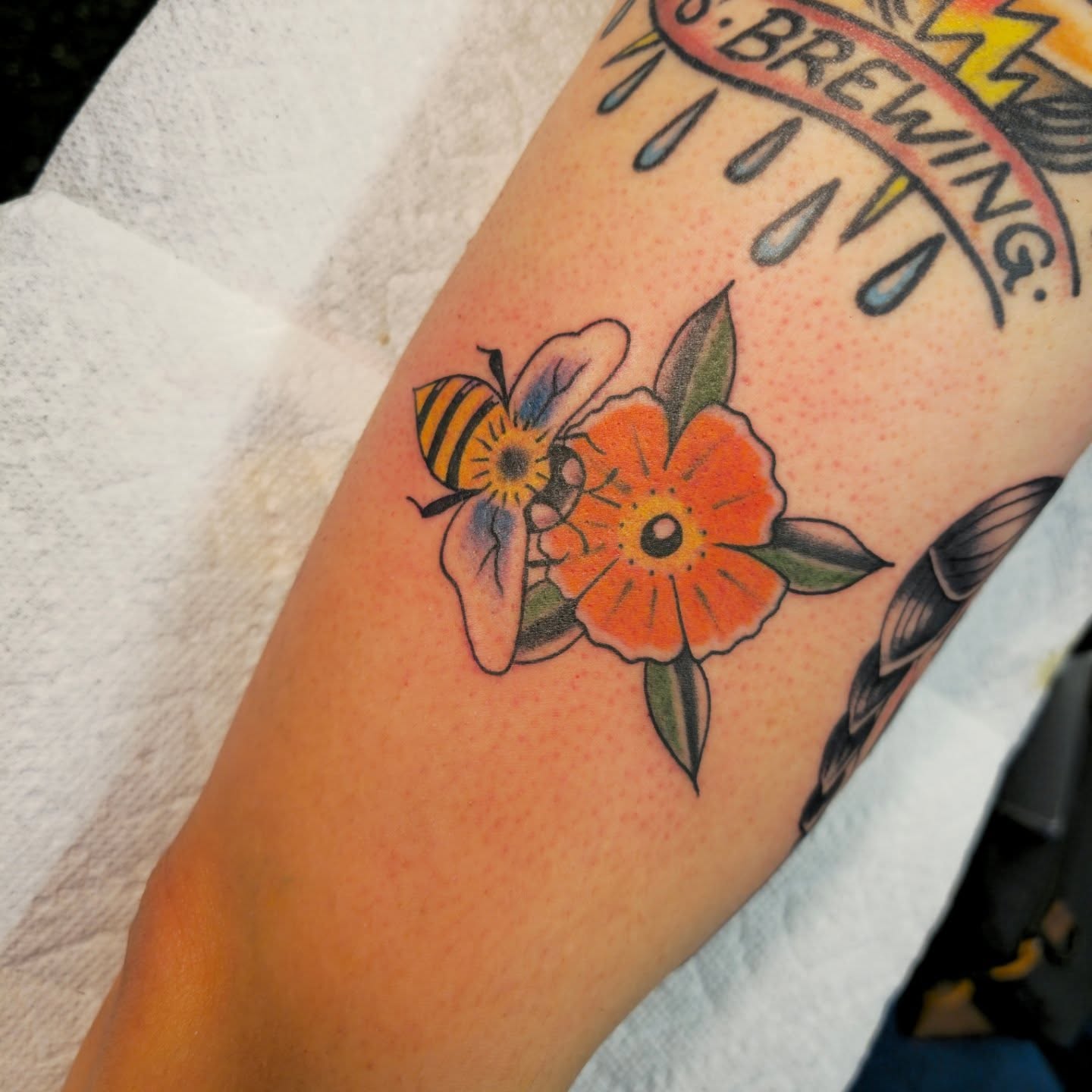 Bee and flower American traditional tattoo on the forearm by Tattoo Artist, Orange, California