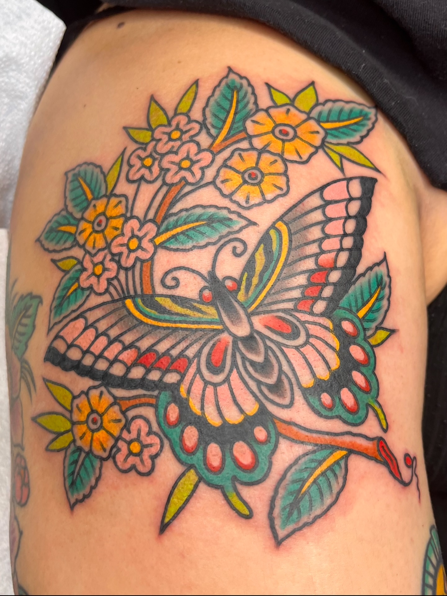 Butterfly and flowers American traditional tattoo on the shoulder by Macy Bird