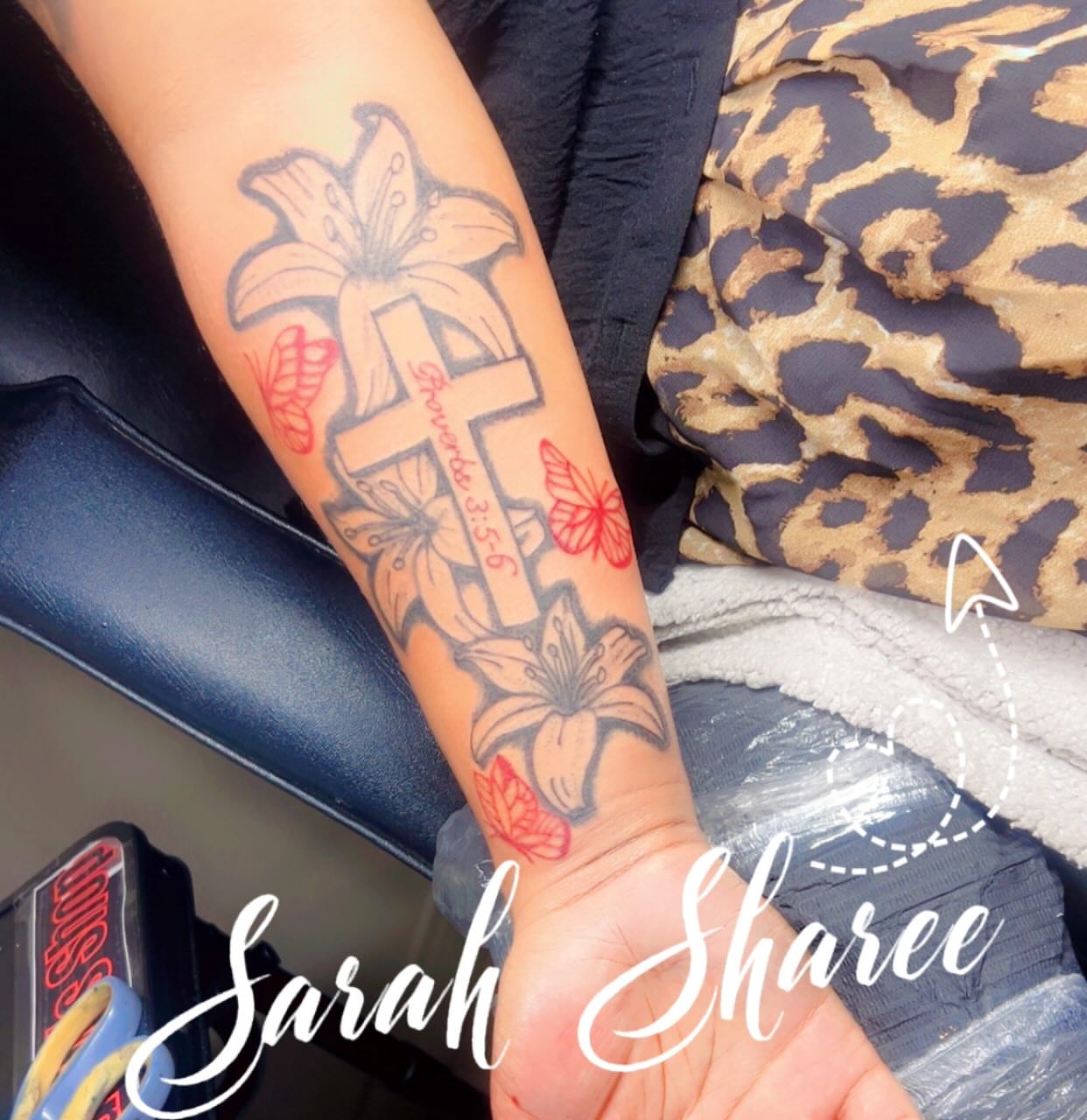 Cross with lilies and butterflies black and grey tattoo on the forearm by Sarah Sharee💃🏽