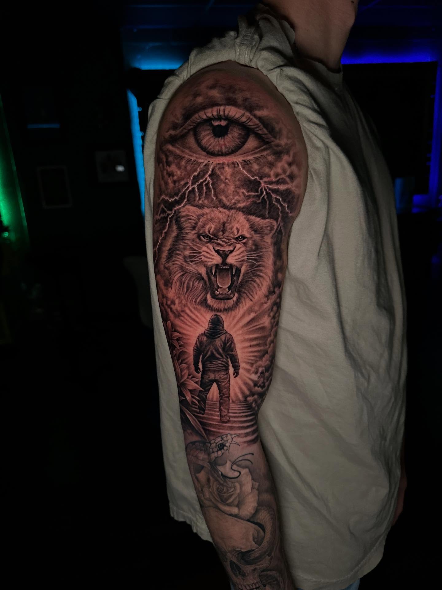Lion and eye realism tattoo on the forearm by Mario Flores Tattoo