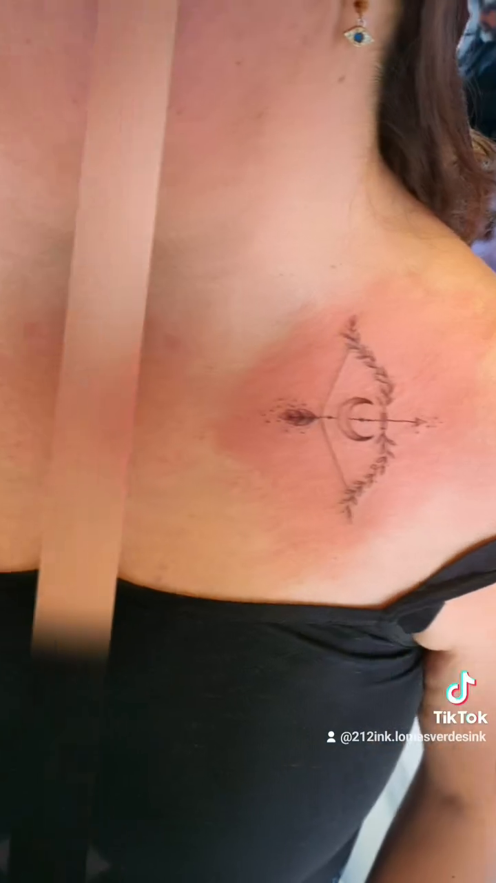 Bow and arrow minimalist tattoo on the chest by Tatuajes Betto Ink Tattoo