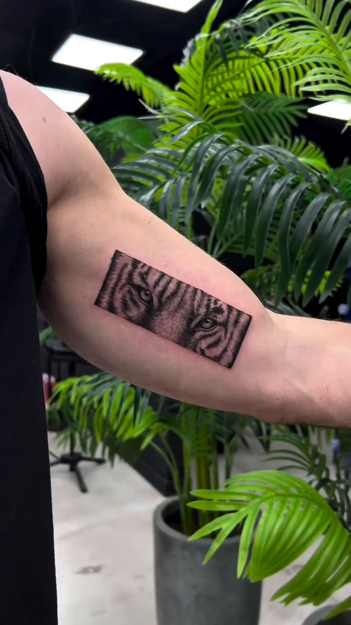 Tiger stripes realism tattoo on the upper arm by Lina Valentina, New York, New York