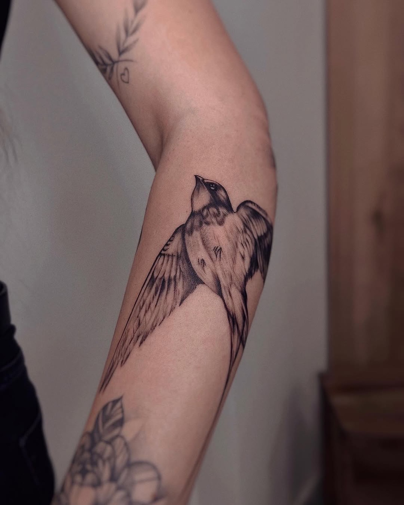 Bird black and grey tattoo on the forearm by Nina Fedorchenko