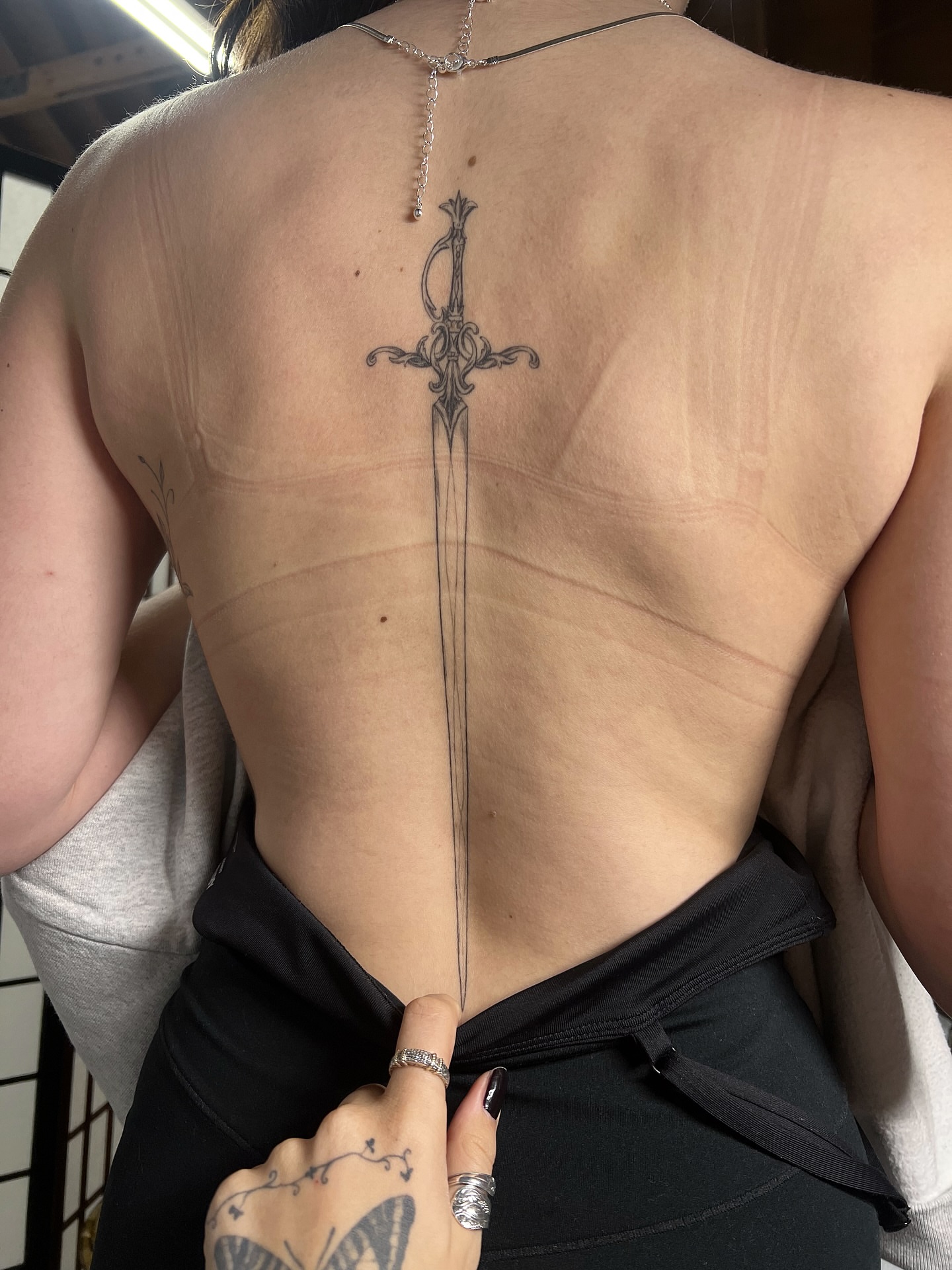 Sword black and grey tattoo on the back by jewel renee