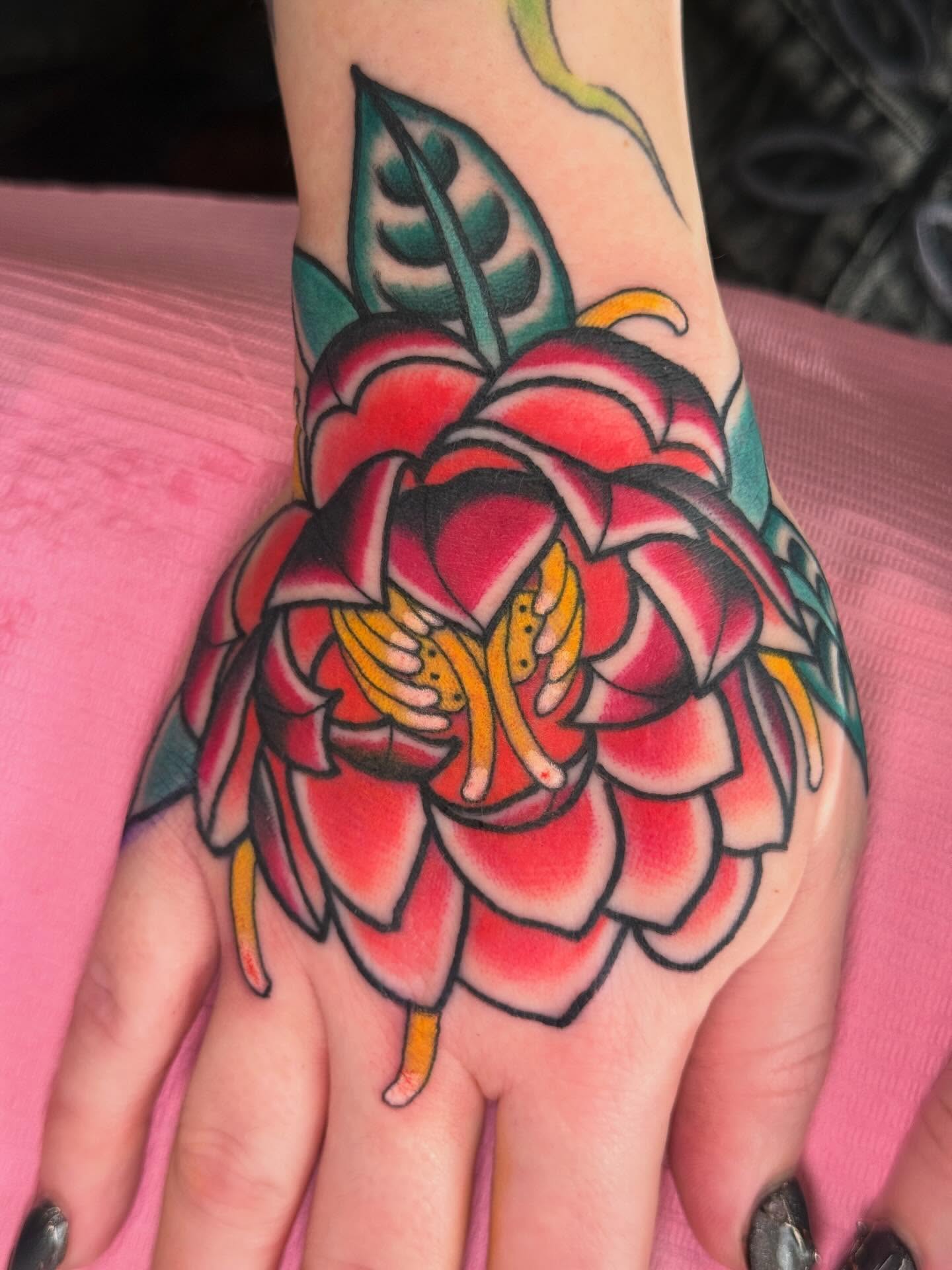 Red flower American traditional tattoo on the hand by Cassie O'Neal DeBord