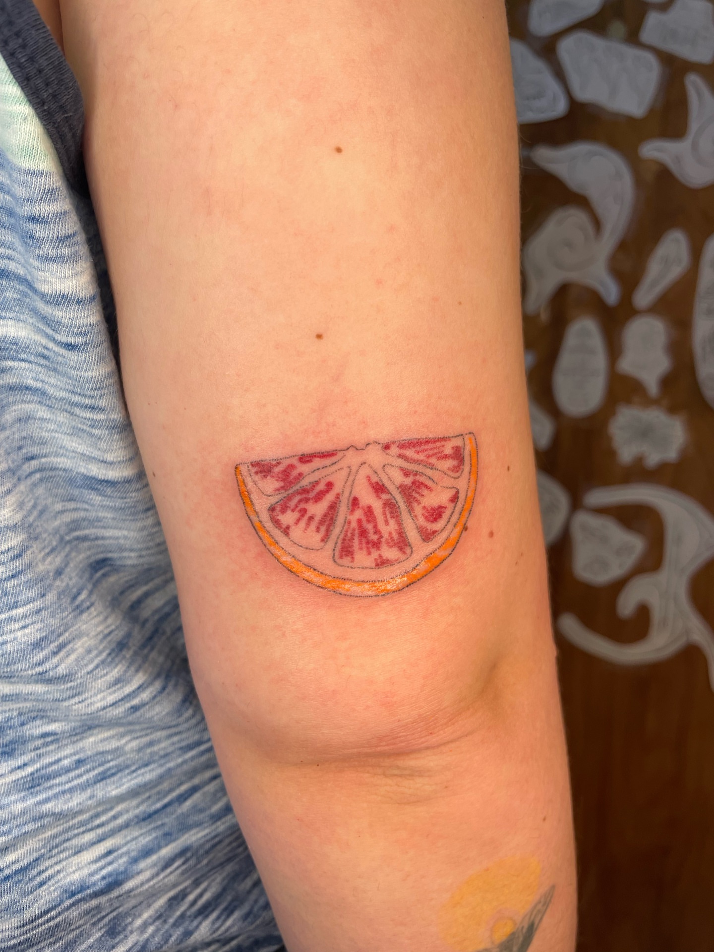 Blood orange slice realism tattoo on the forearm by cait