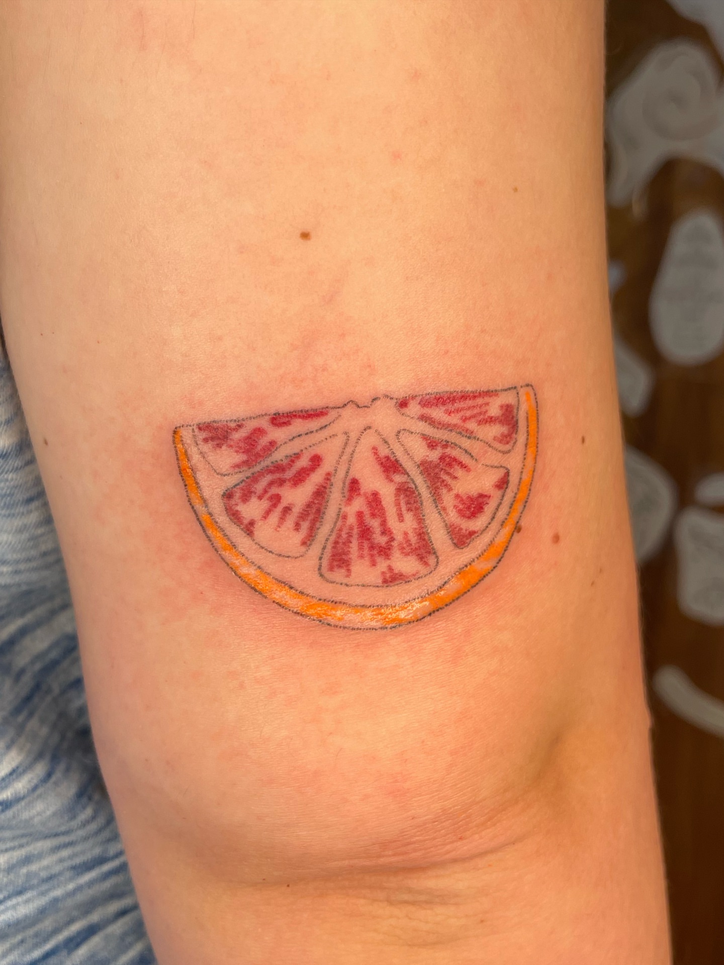 Blood orange slice realism tattoo on the forearm by cait