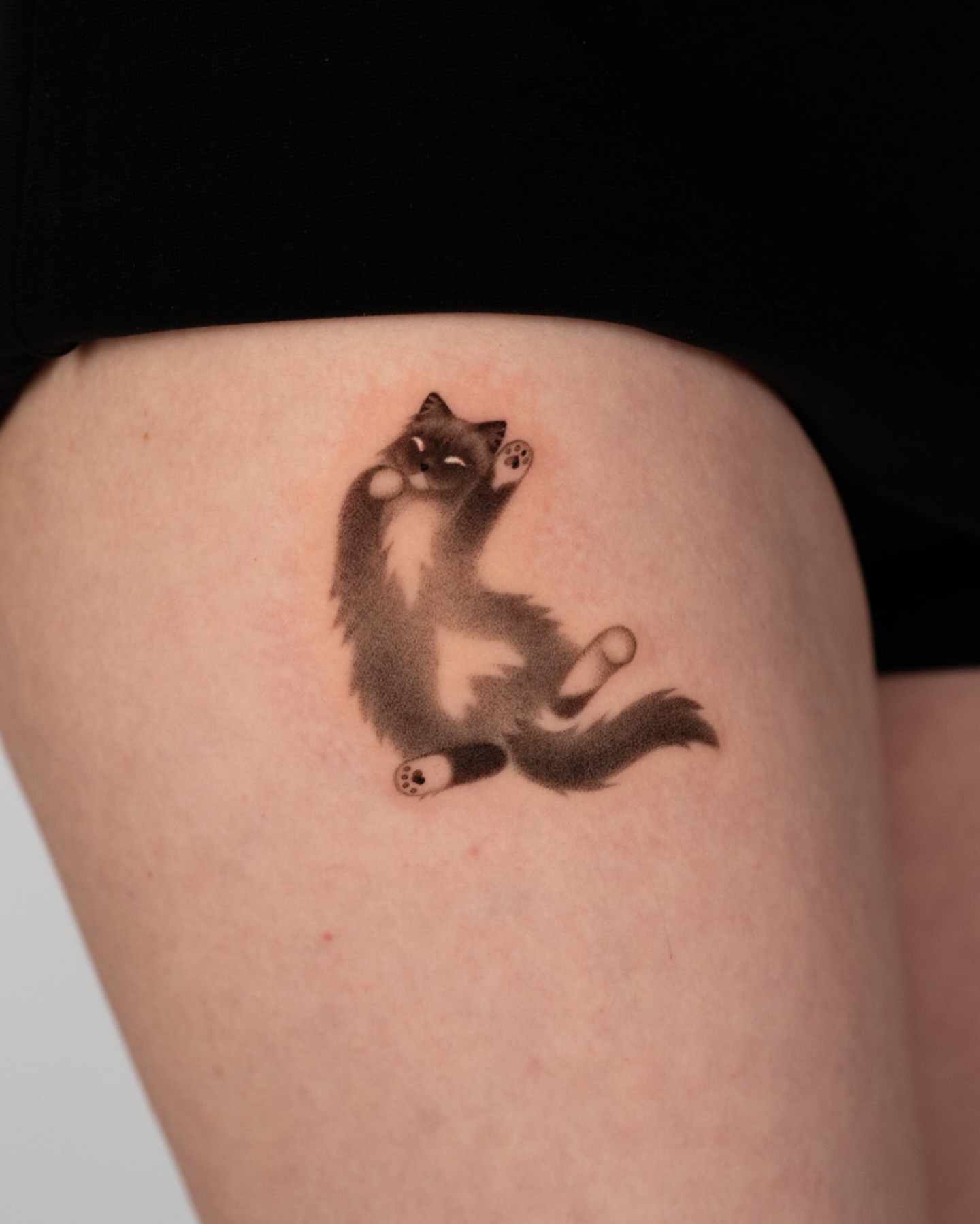 Cat black and grey tattoo on the thigh by Toki