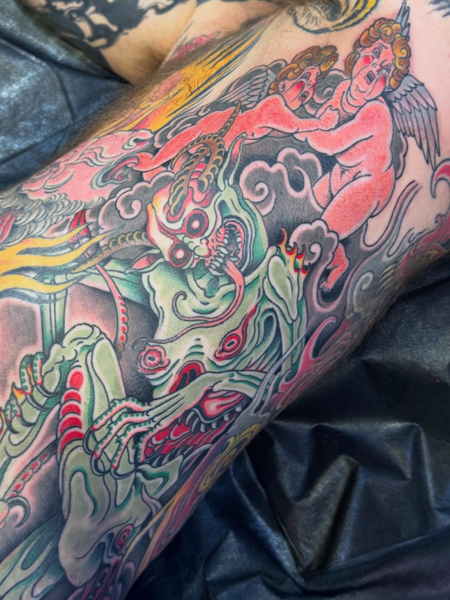 Demons and angels American traditional tattoo on the upper arm by Derek Noble, San Francisco, California