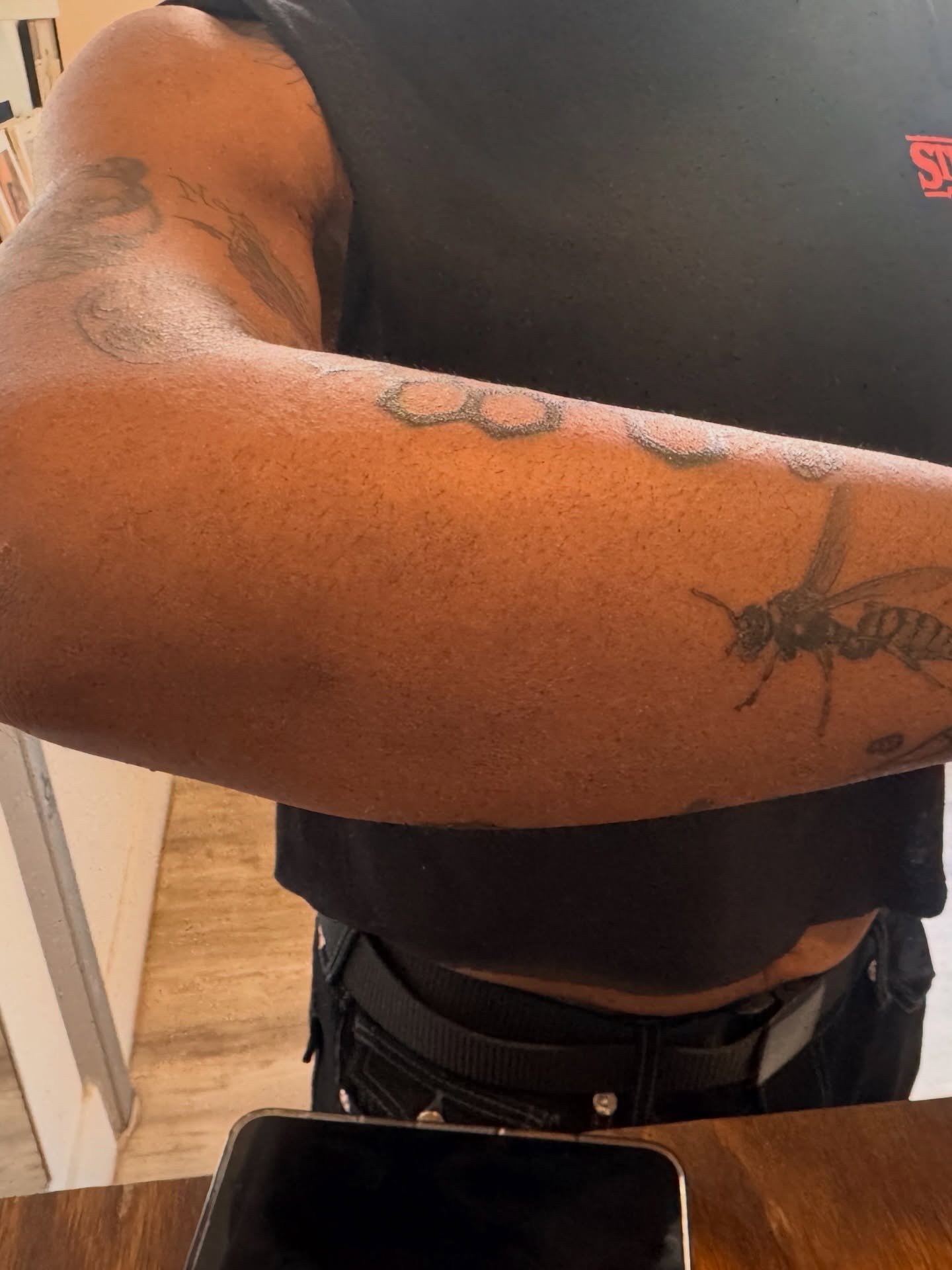 Bee black and grey tattoo on the forearm by Sam Padilla