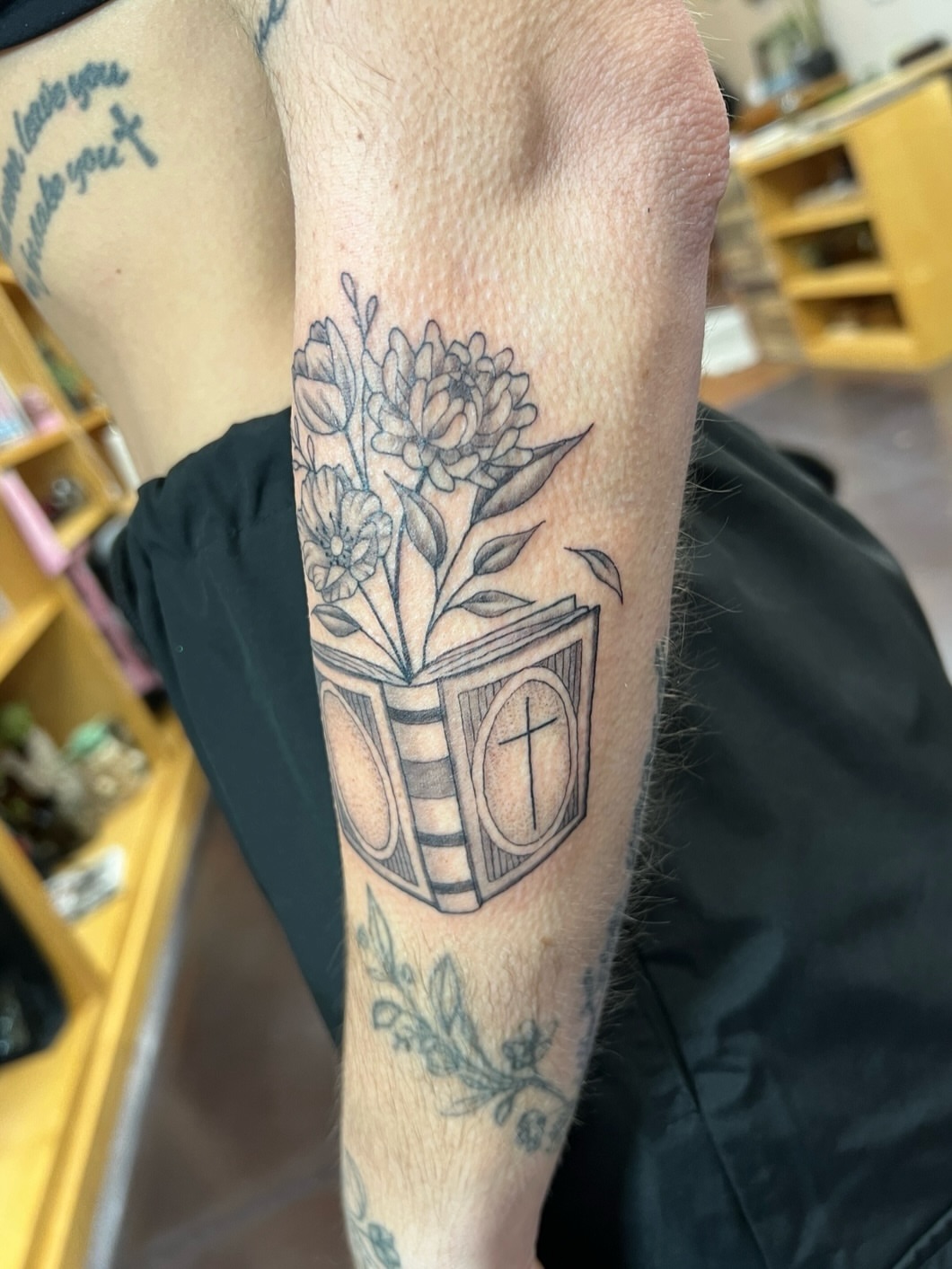 Book with flowers black and grey tattoo on the forearm by ๐๐ฒ๐ต๐ ๐๐ช๐พ๐ป๐ฒ๐ต๐ช ๐ฃ๐ช๐ฝ๐ฝ๐ธ๐ธ๐ผ