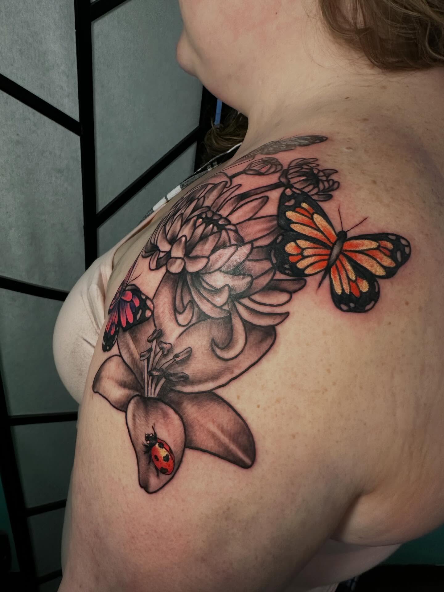 Butterfly and flowers realism tattoo on the shoulder by Elisha B🦷