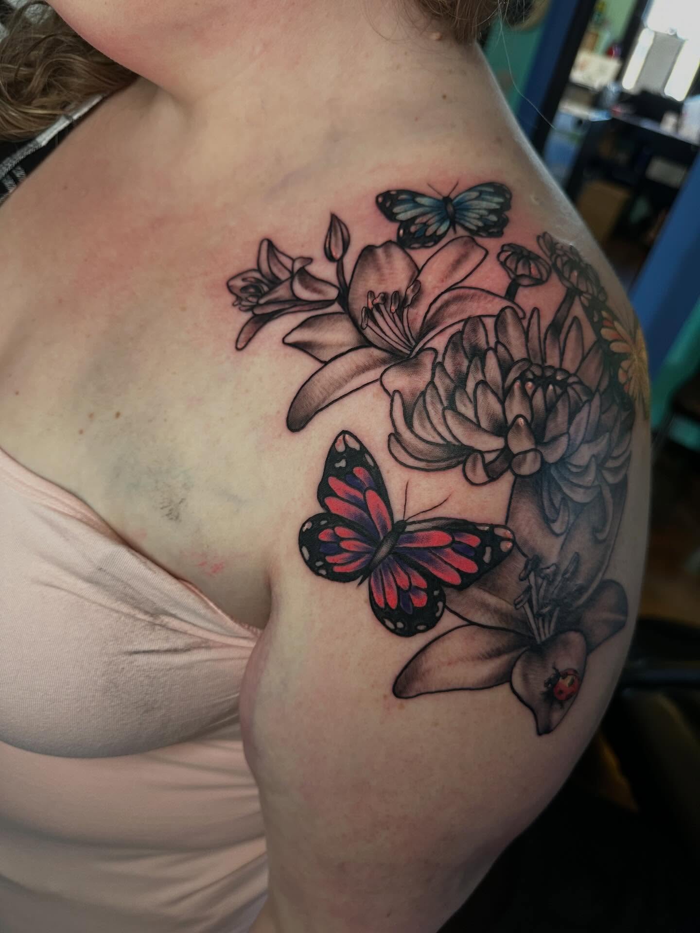 Butterfly and flowers realism tattoo on the shoulder by Elisha B🦷