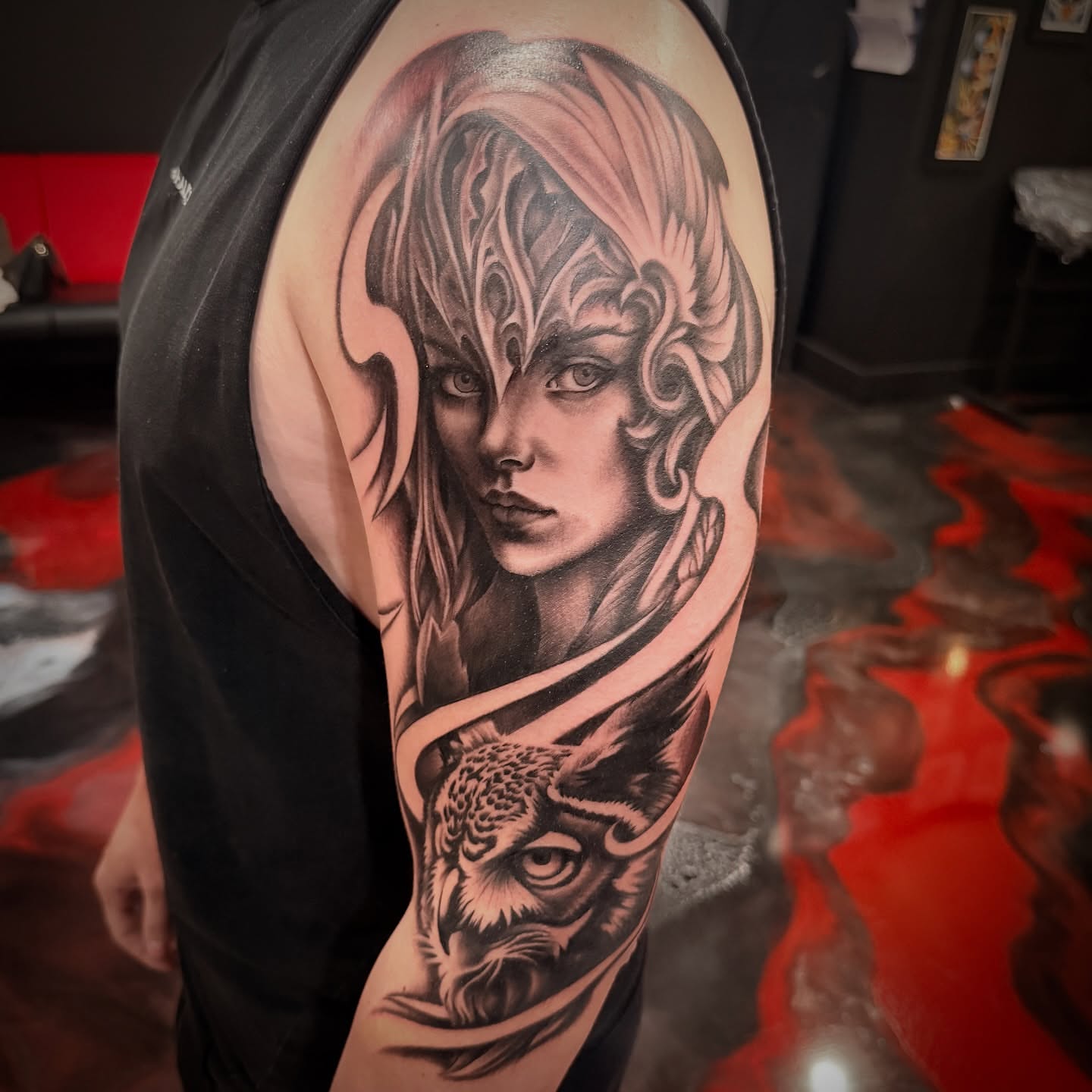 Woman with owl realism tattoo on the upper arm by Zack Havoc