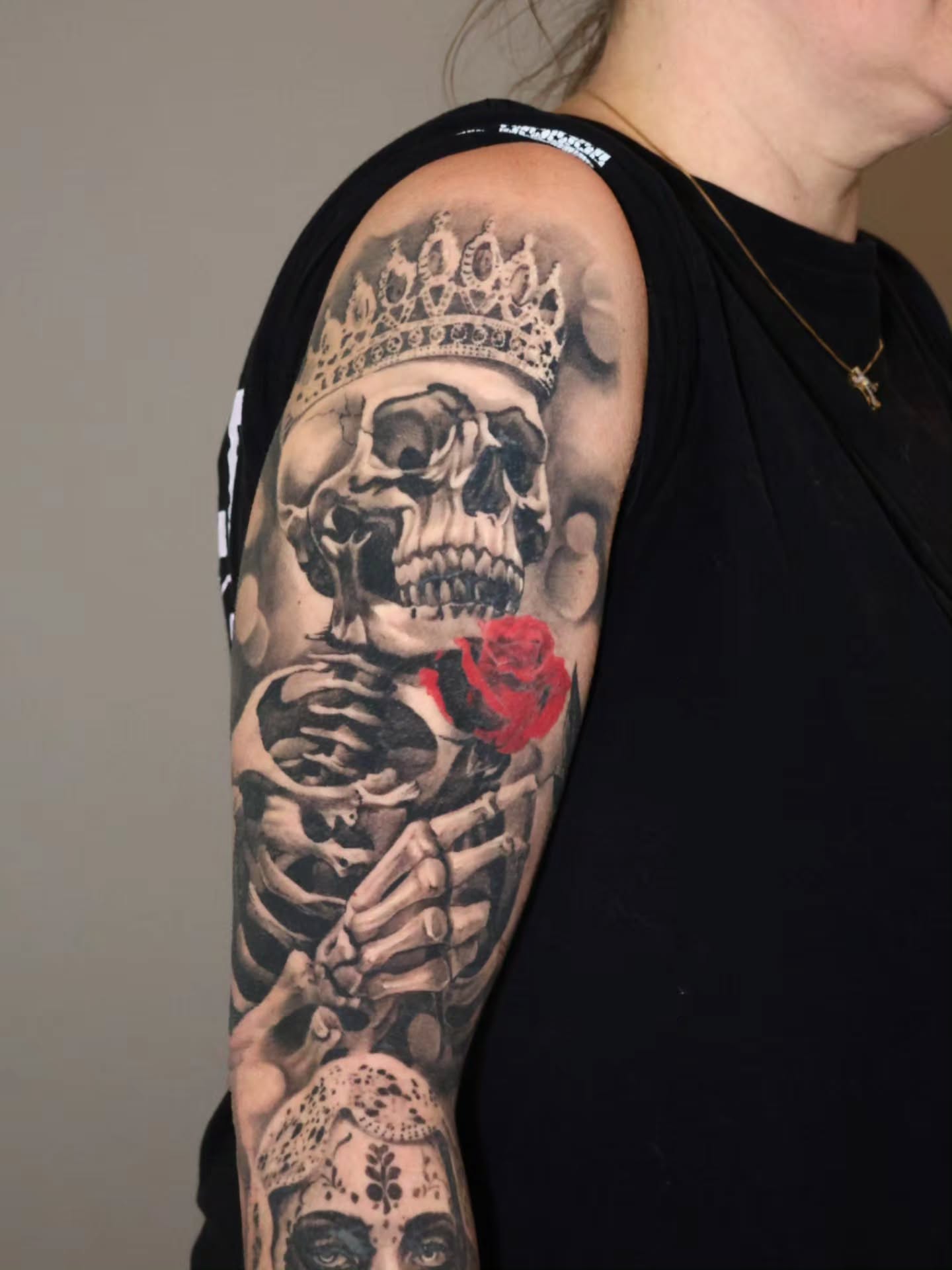 Skeleton with crown and rose realism tattoo on the upper arm by Jesus Bravo