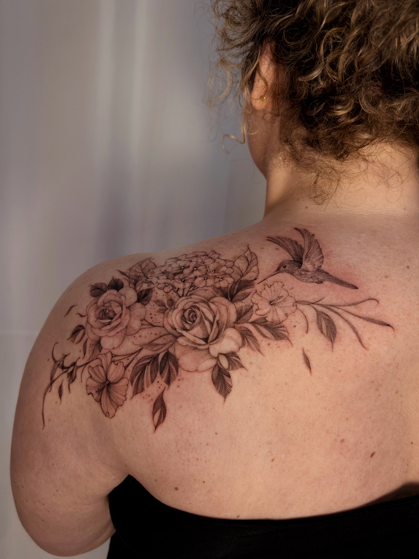 Floral bouquet with hummingbird realism tattoo on the shoulder by Tattoo Yulia Kononenko