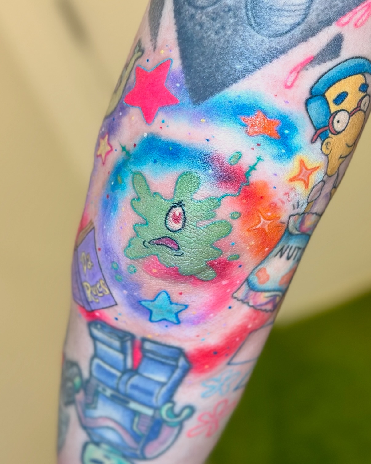 Space-themed cartoon characters watercolor tattoo on the forearm by Sophie ✨ Nashville Tattoo Artist ✨