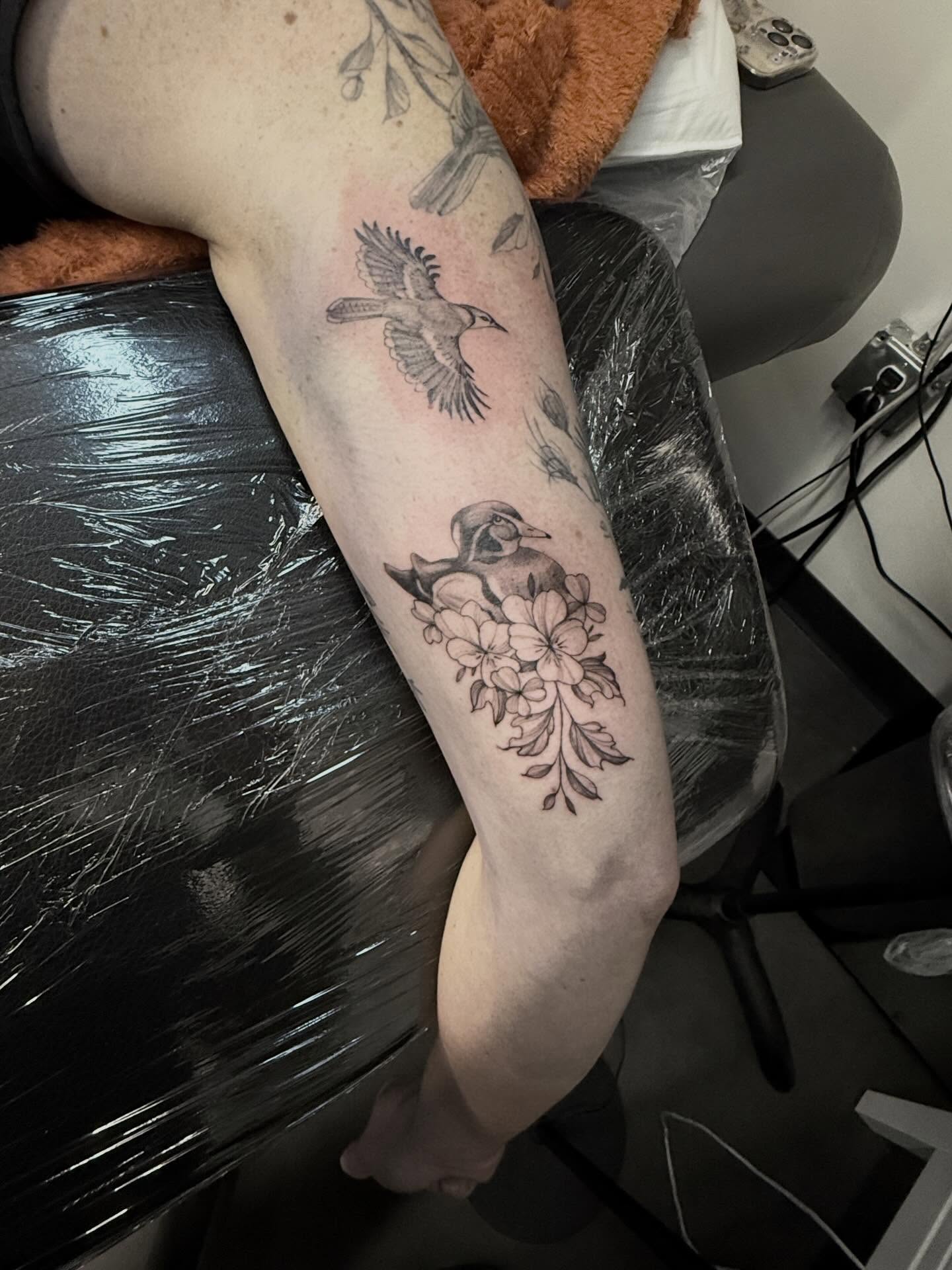 Bird and flowers black and grey tattoo on the forearm by Peter Harren