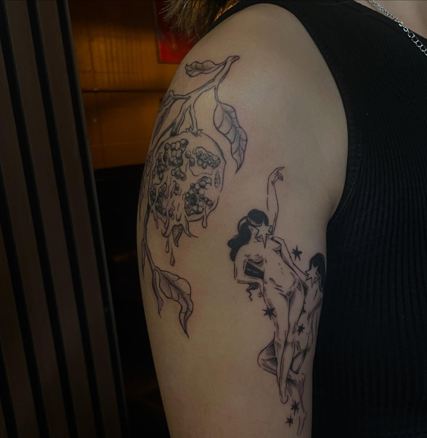 Pomegranate and celestial figure realism tattoo on the shoulder by Trinity
