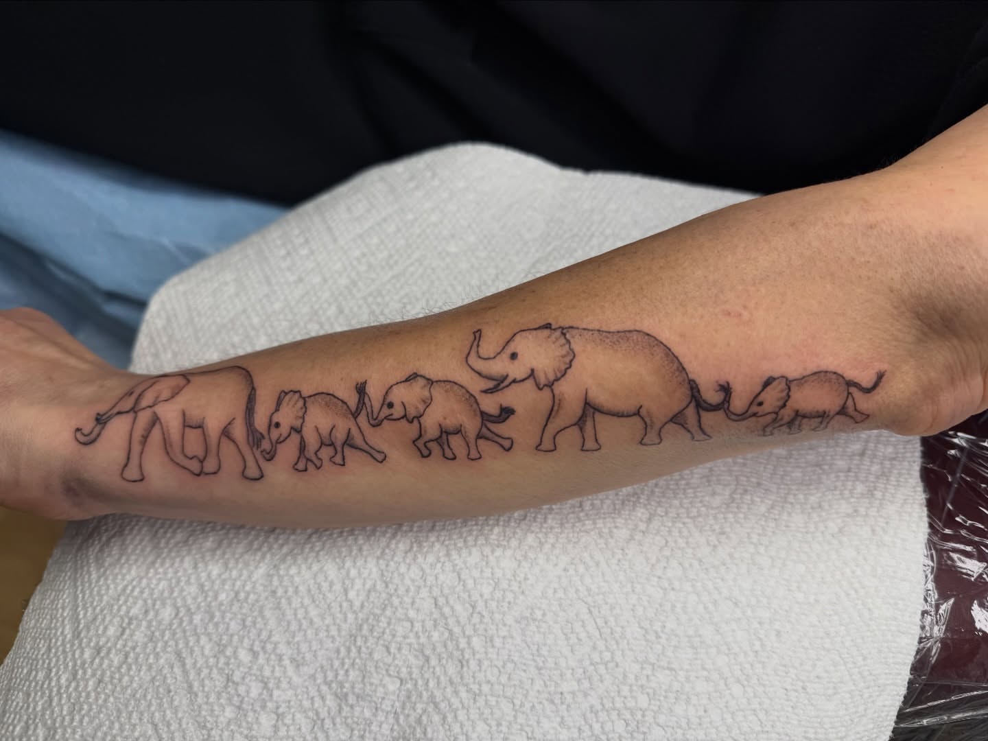 Elephant family black and grey tattoo on the forearm by Giana Masso