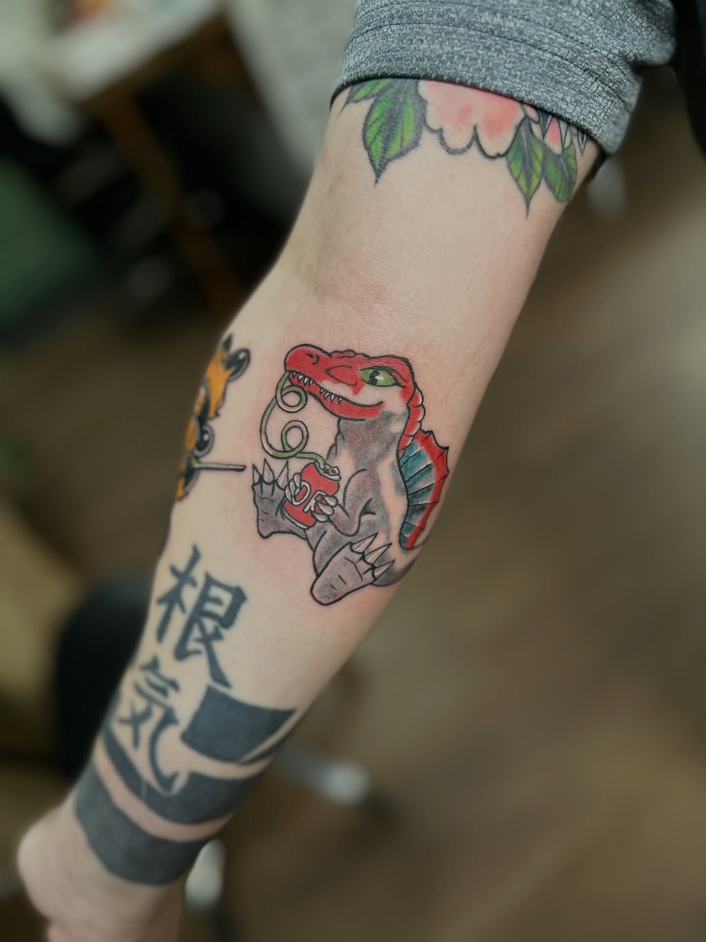 Dinosaur American traditional tattoo on the forearm by Nick Weaver aka gibby sometimes gilbert
