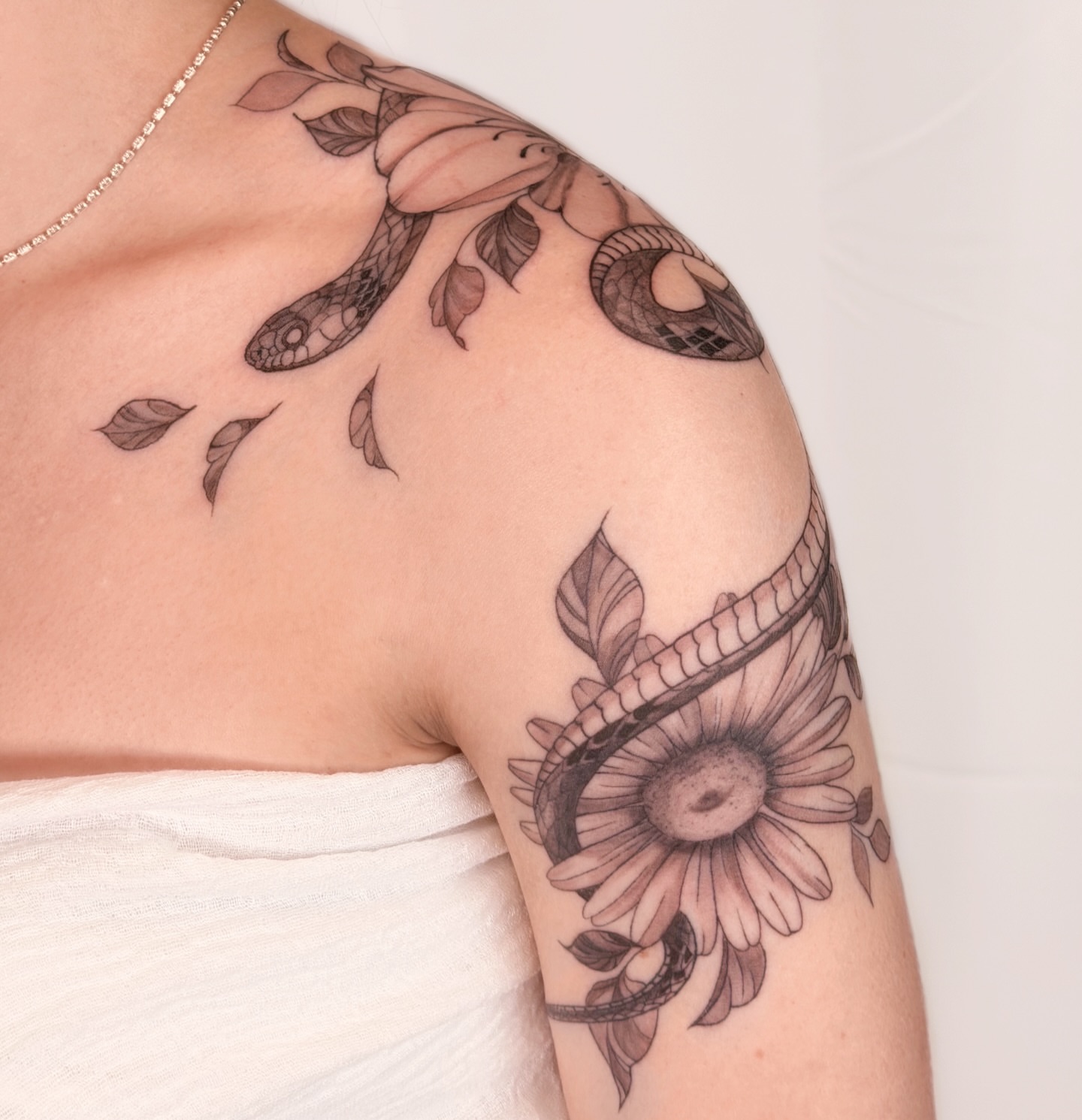 Snake and flower realism tattoo on the shoulder by Charlotte