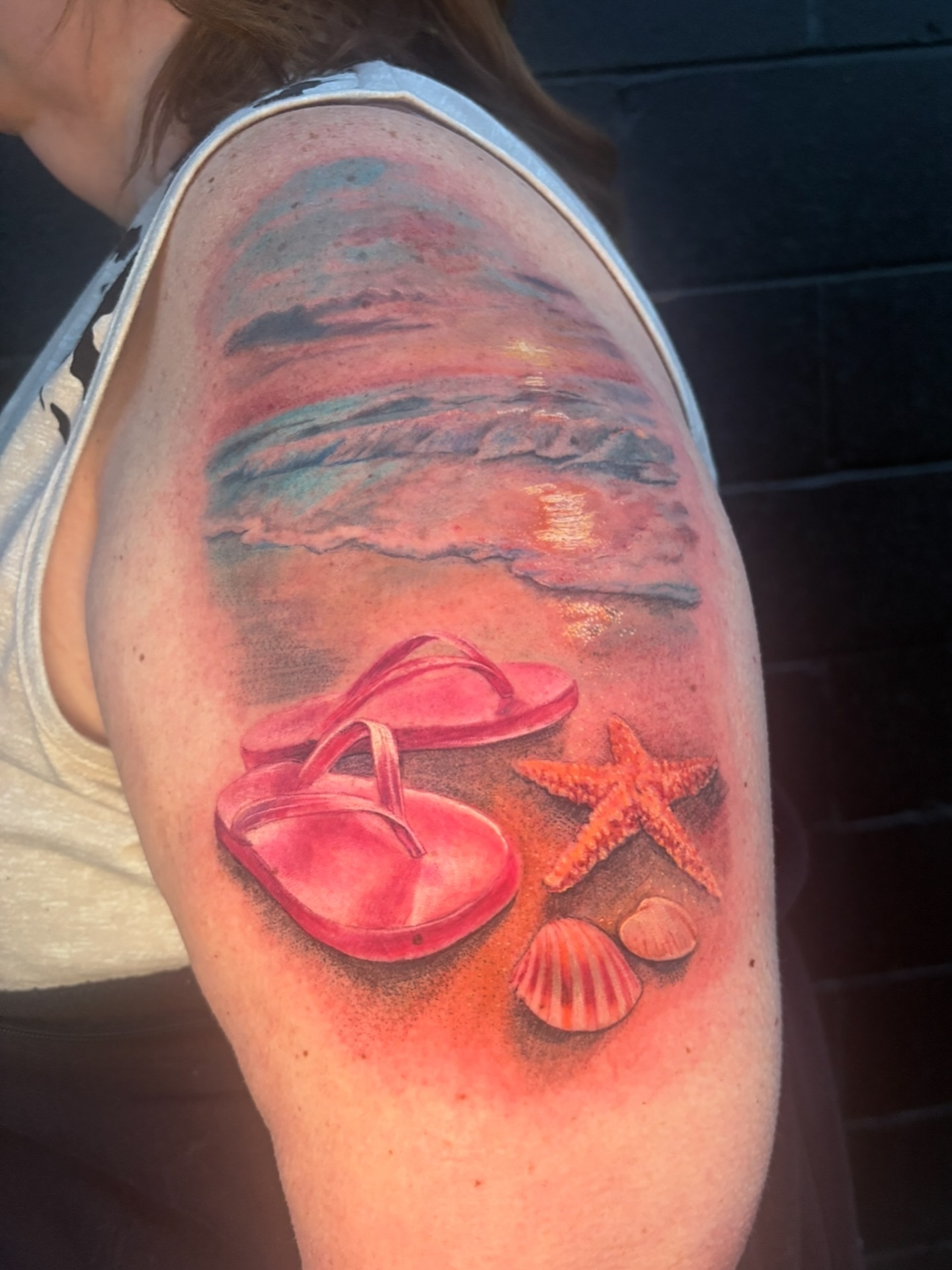 Beach scene realism tattoo on the upper arm by Caitlin Curtis Tattoos & Booking, Dayton, Ohio