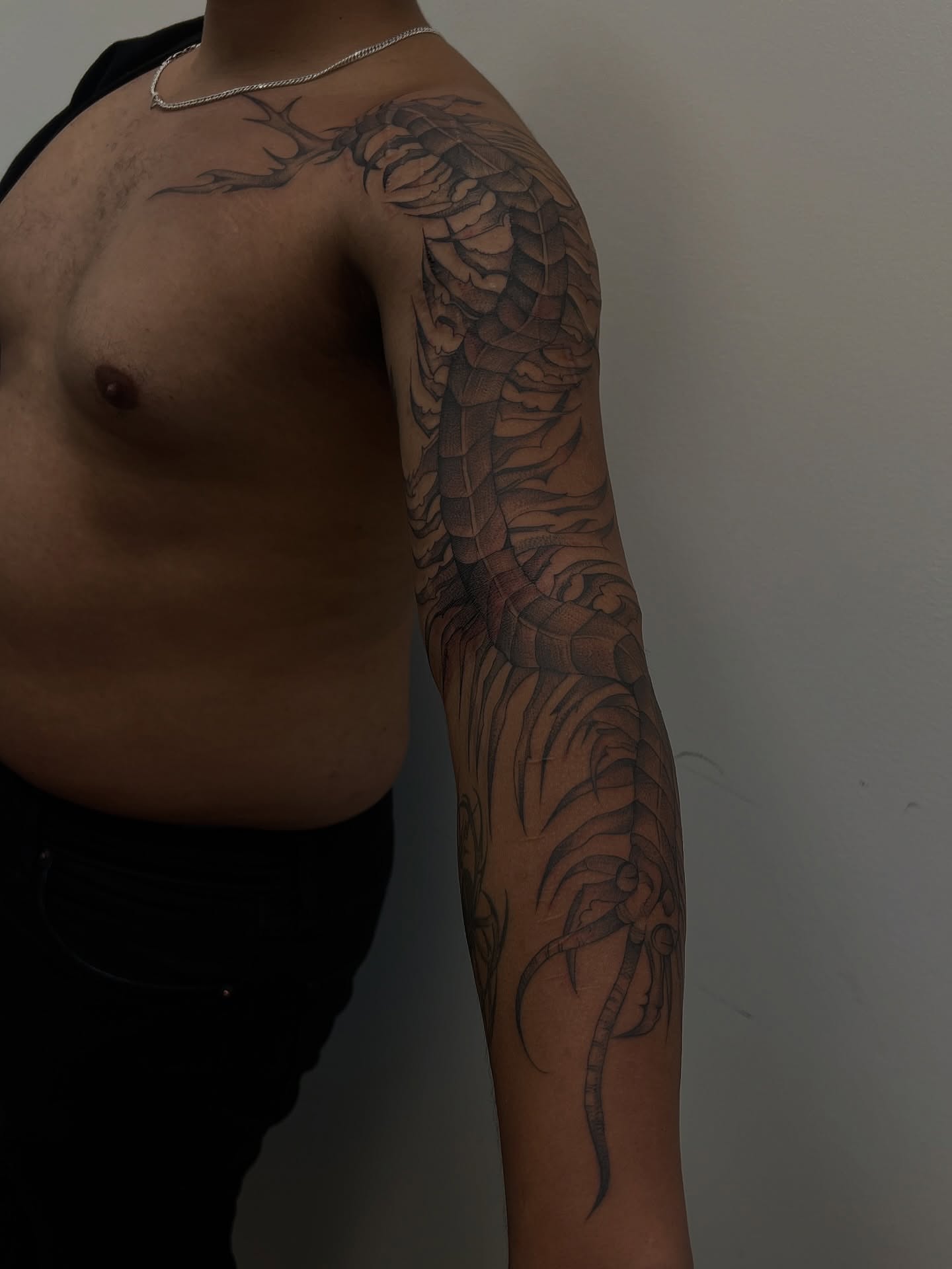 Dragon black and grey tattoo on the upper arm by ashlyn rene