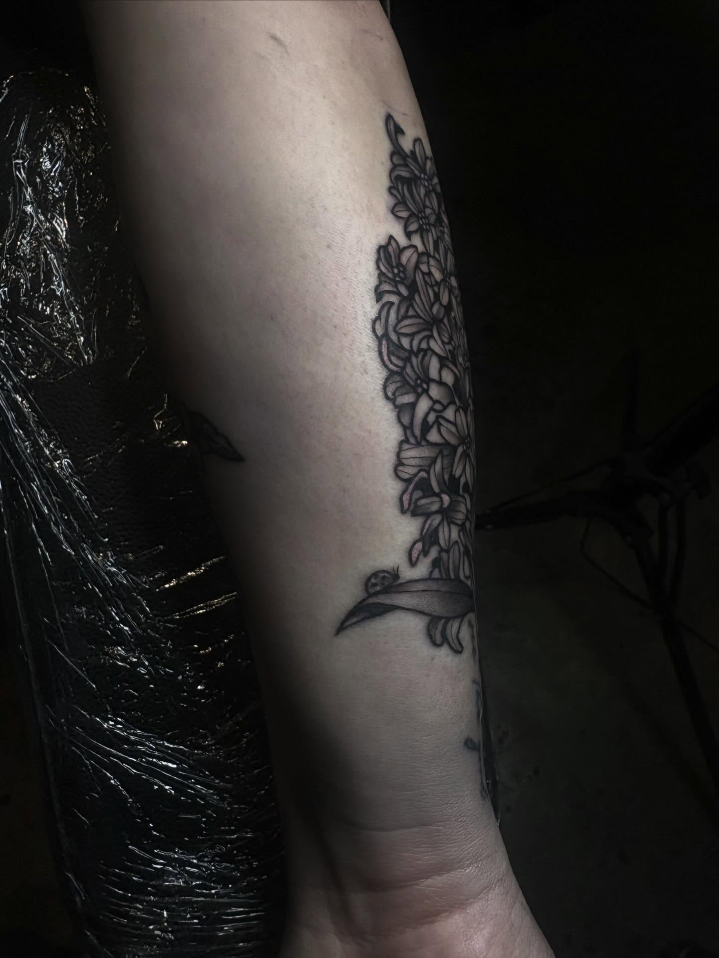 Floral vine with bird black and grey tattoo on the forearm by Mim