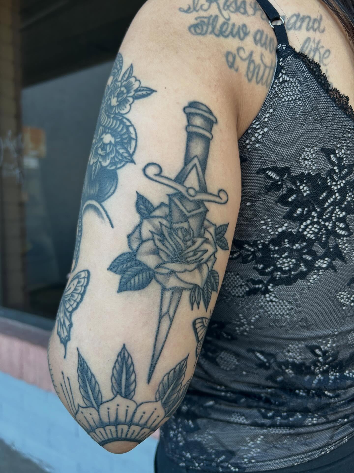Sword and roses black and grey tattoo on the forearm by Janelle McCarthy