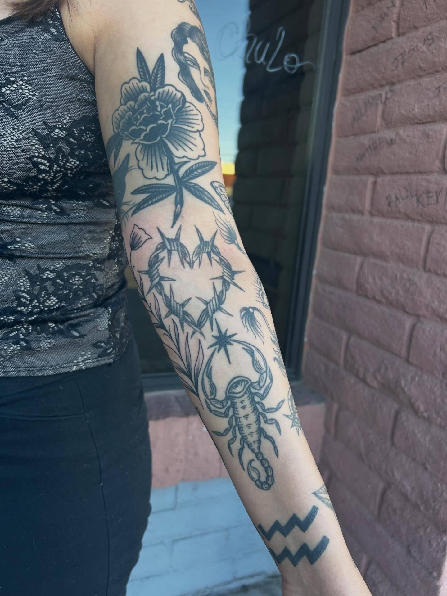 Floral and scorpion black and grey tattoo on the forearm by Janelle McCarthy