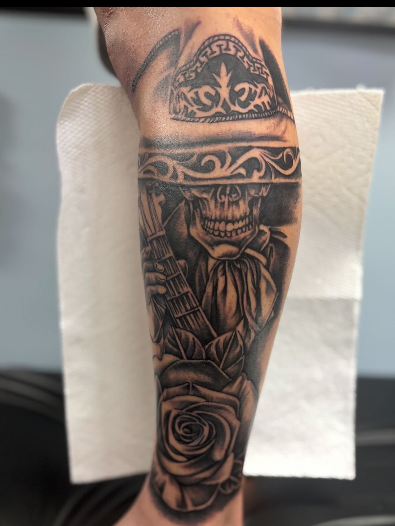 Skull playing guitar realism tattoo on the forearm by Jesus Pubert Munster