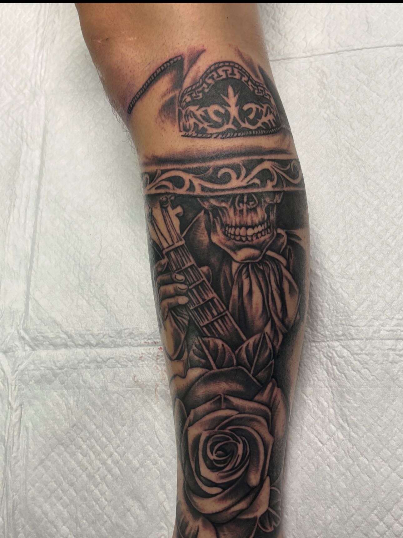 Skull playing guitar realism tattoo on the forearm by Jesus Pubert Munster