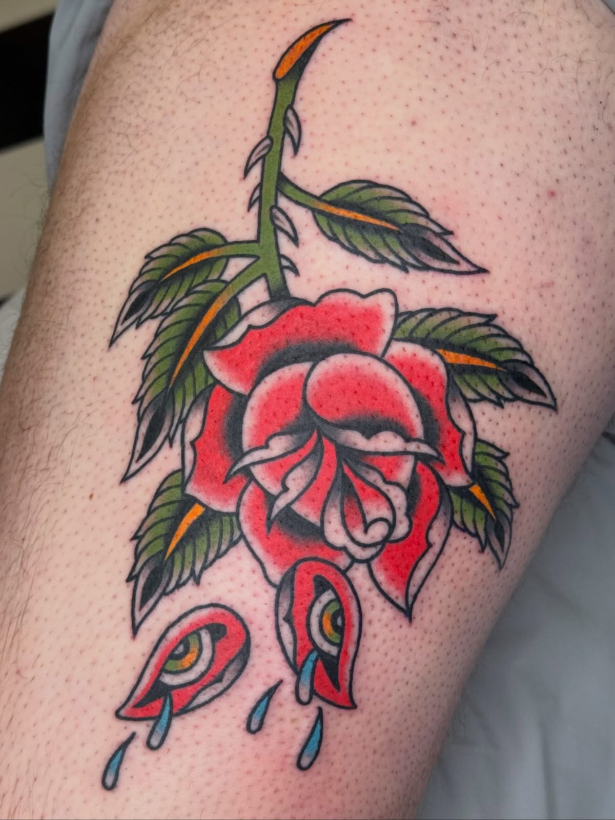 Tearful rose American traditional tattoo on the thigh by Emma Eaton