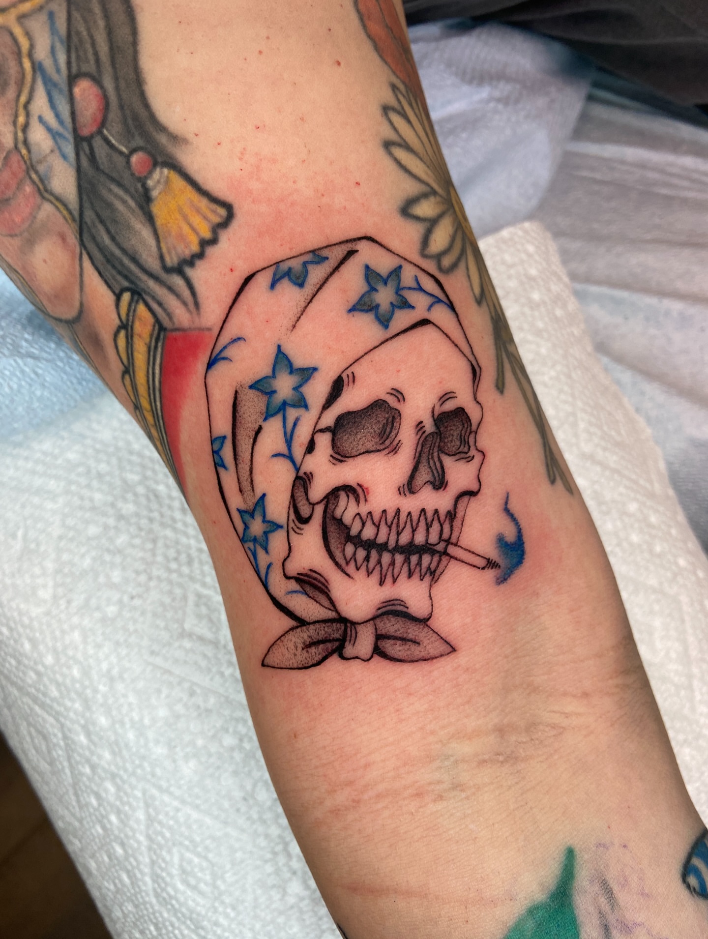 Skull with bandana American traditional tattoo on the forearm by Quinn